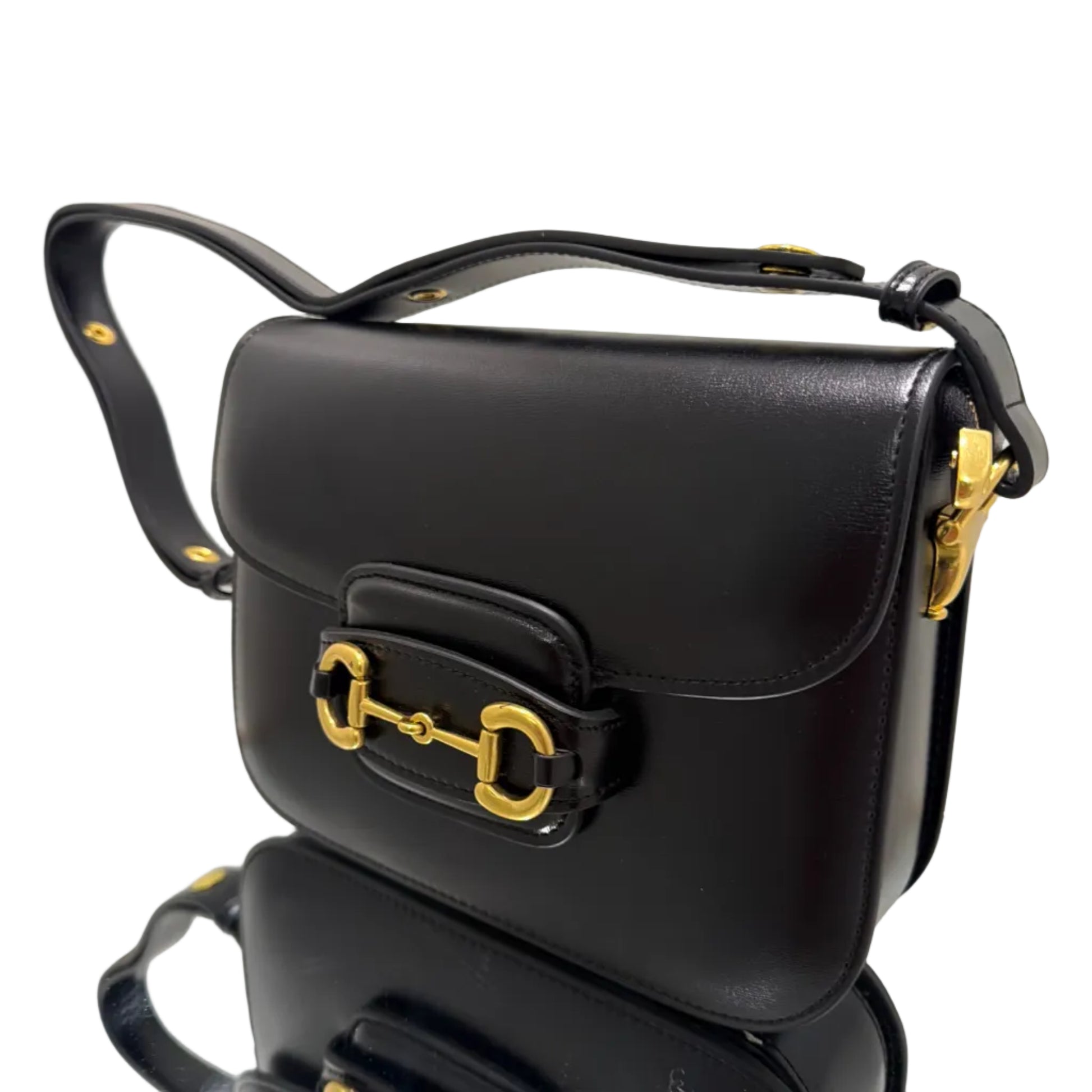 Black handbag with gold hardware on a white background
