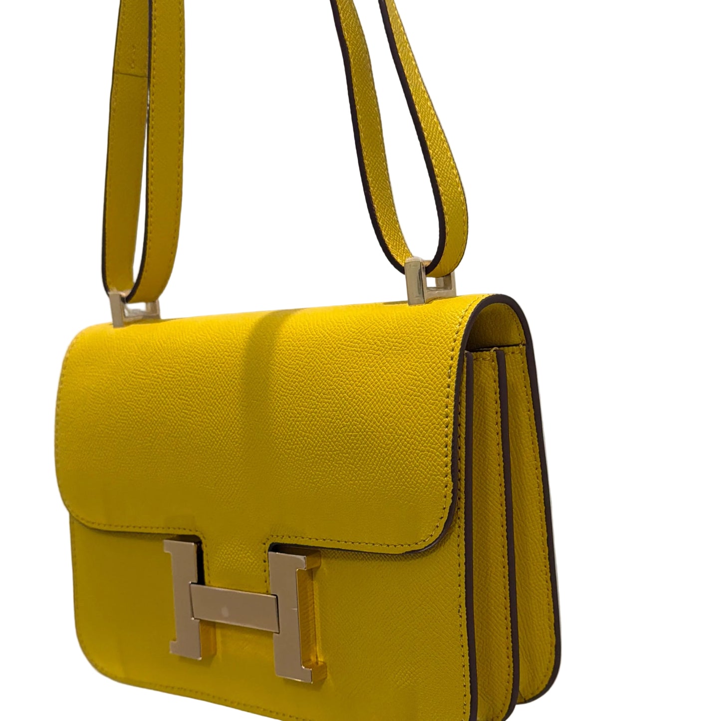 Yellow handbag with a gold 'H' logo on a white background