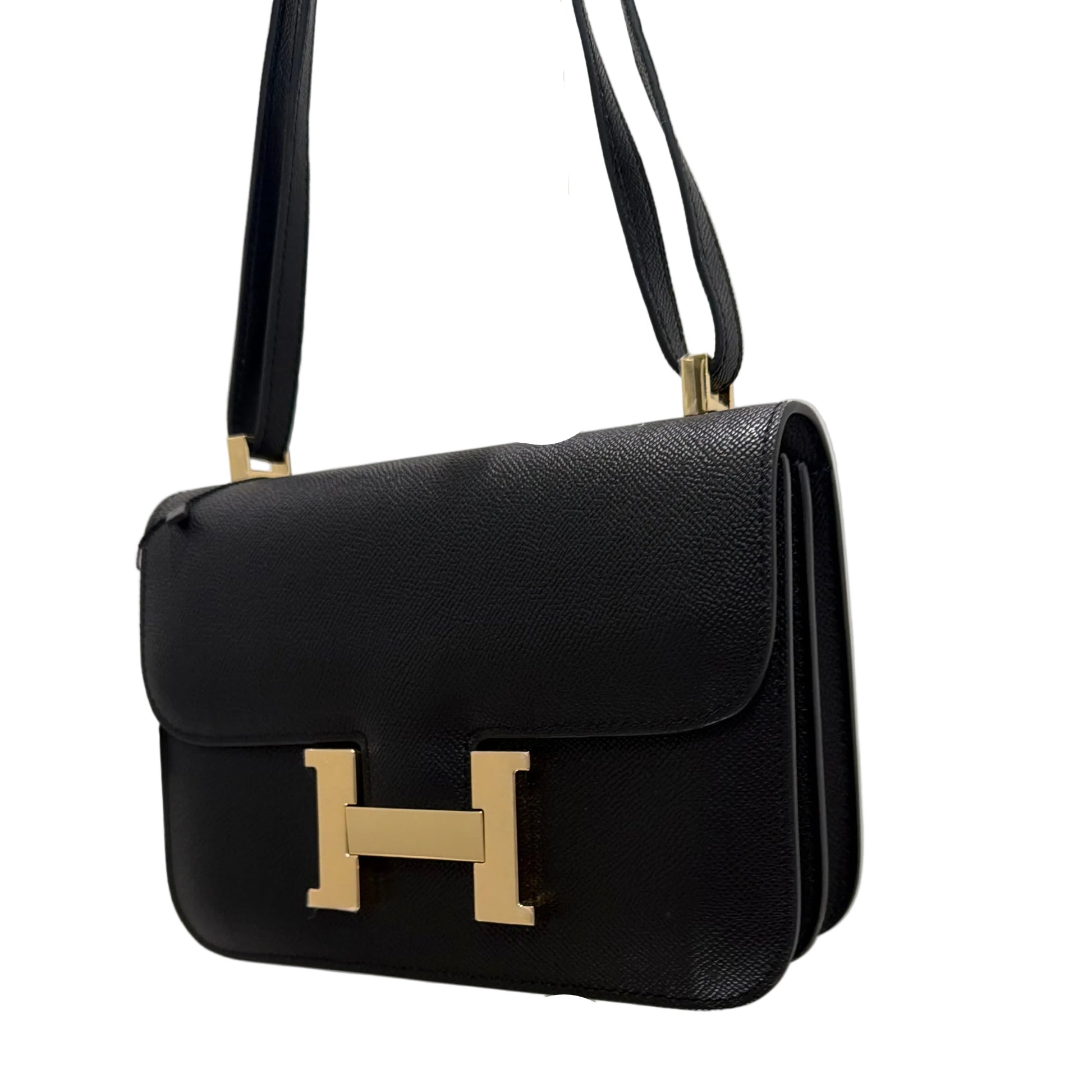 Black handbag with gold hardware on a white background