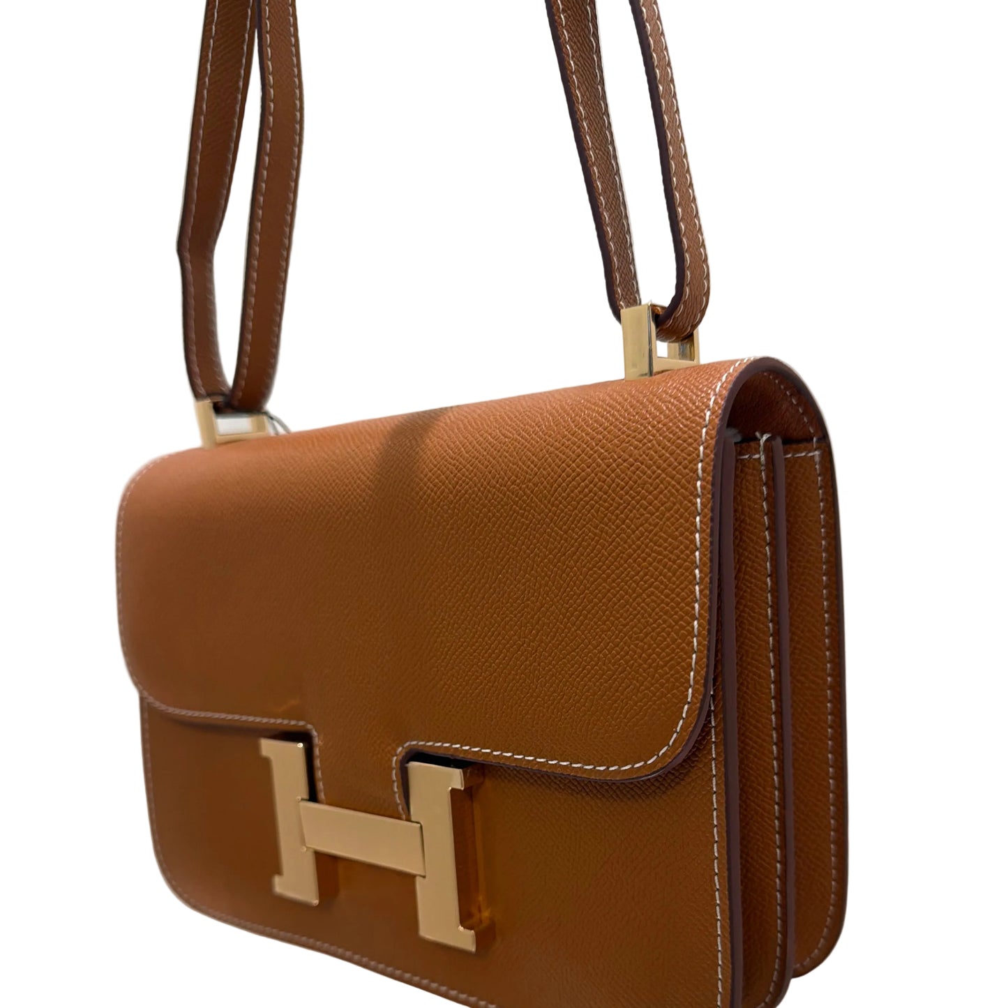 Brown leather handbag with gold clasp on a white background