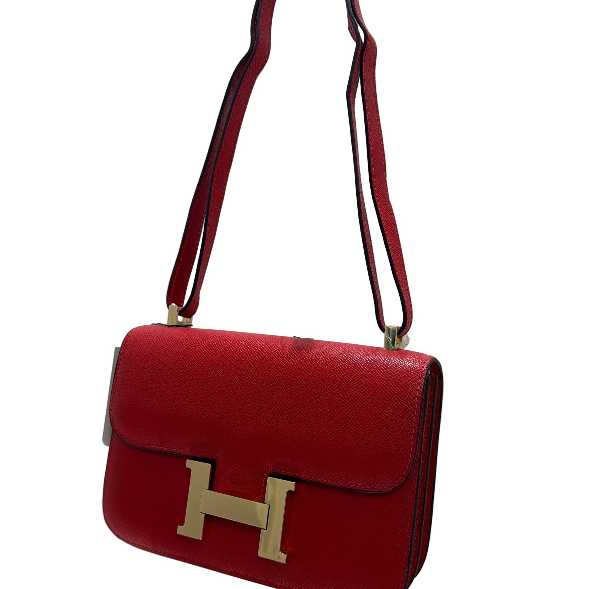 Red handbag with gold 'H' logo on a white background