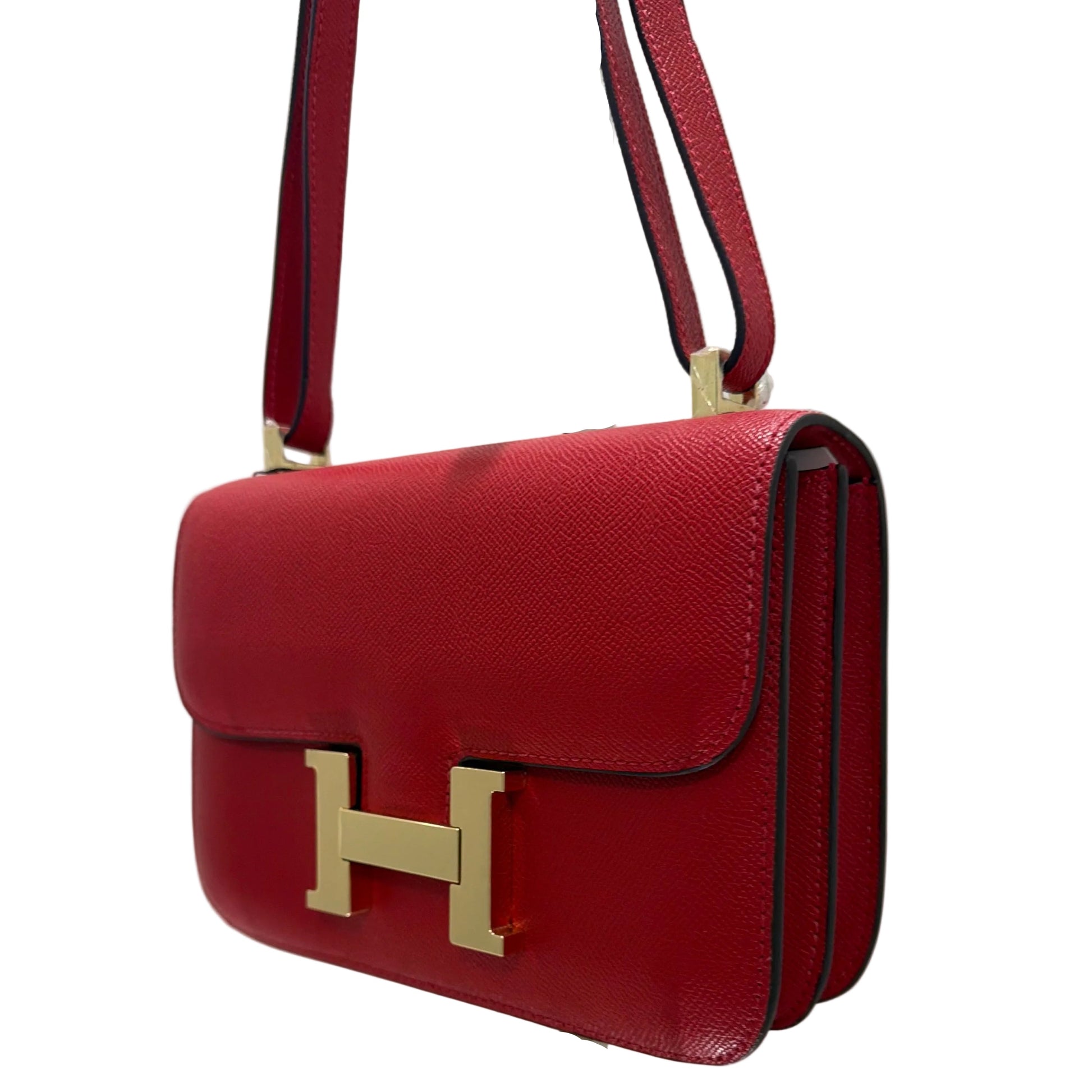 Red wallet with gold 'H' clasp on a white background