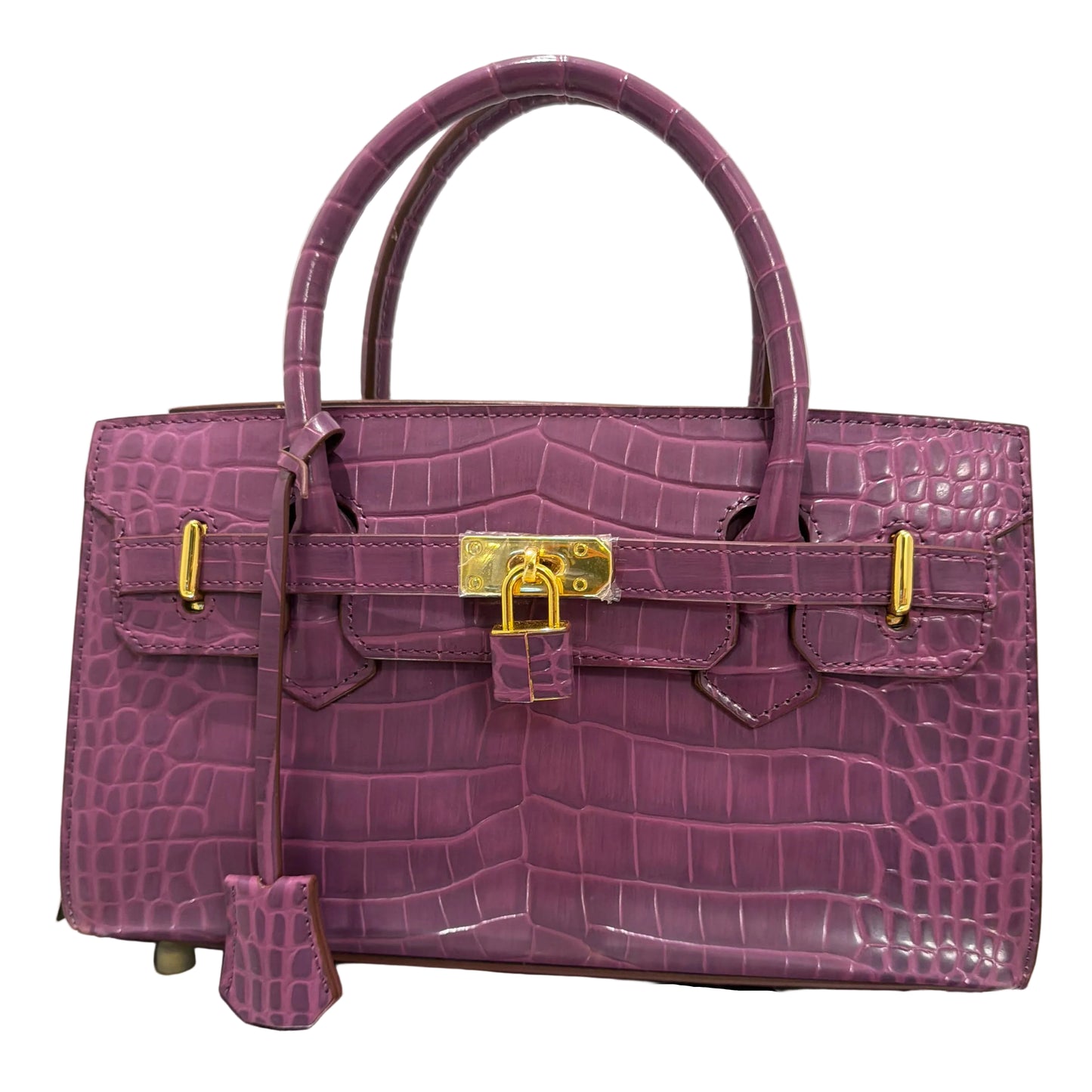 Purple crocodile skin handbag with gold hardware on a light gray background