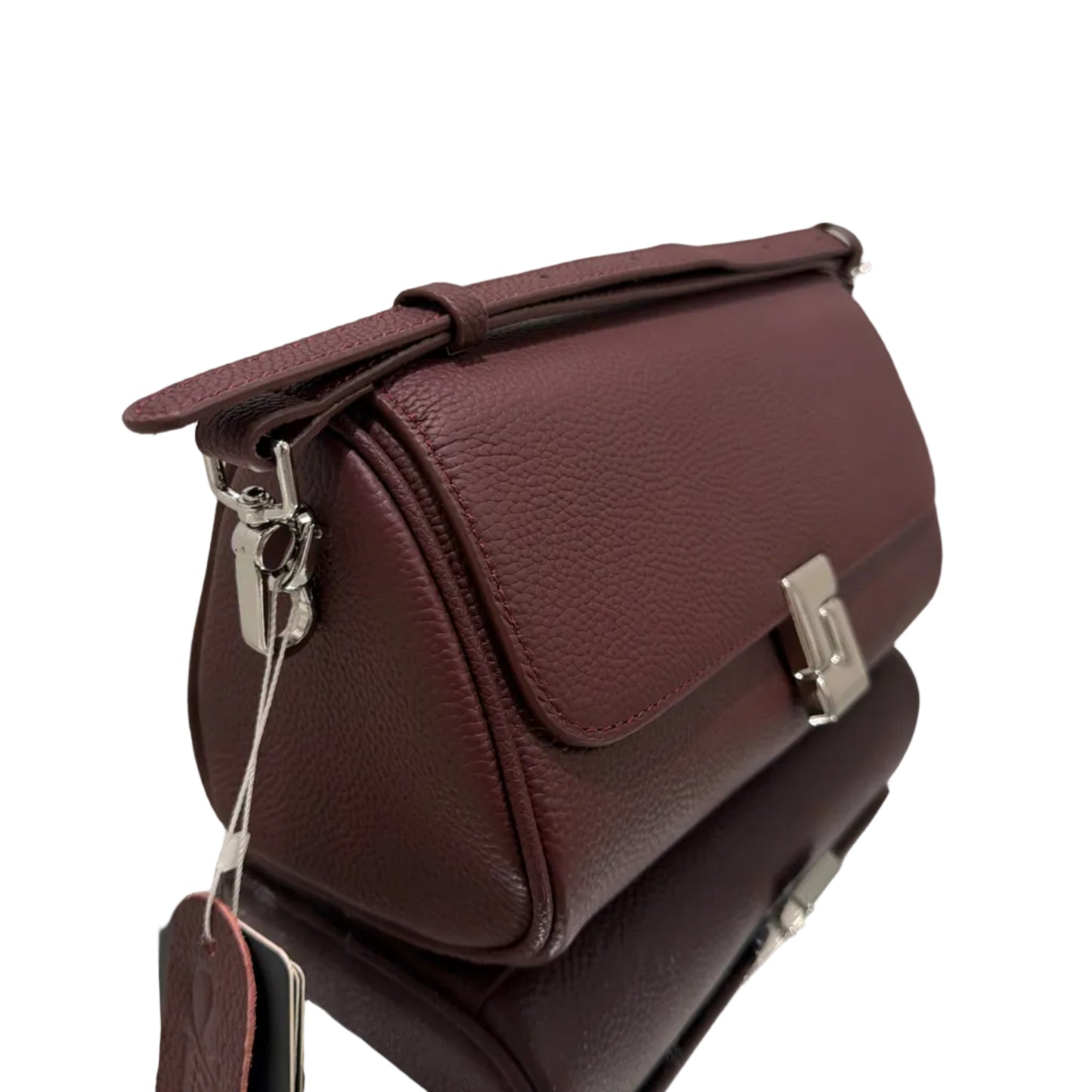 Brown leather handbag with gold hardware on a reflective surface