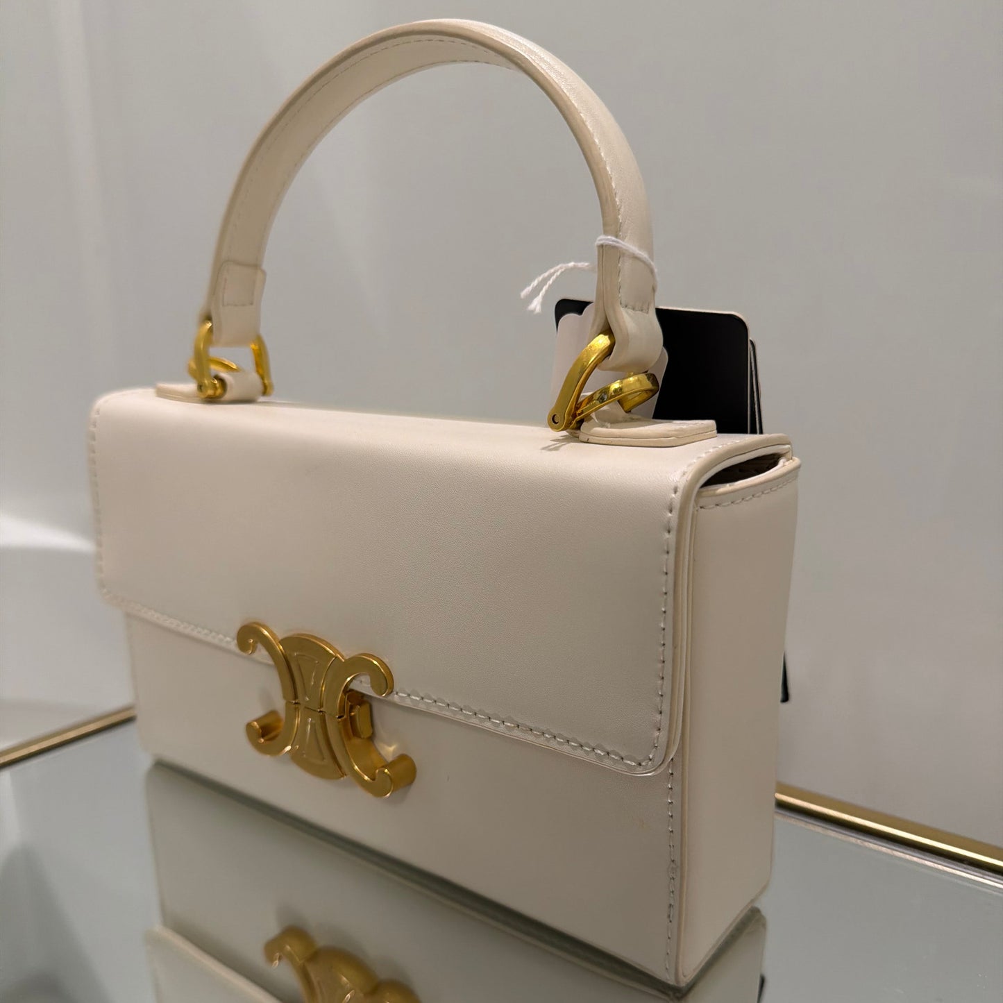 White handbag with gold accents on a white background