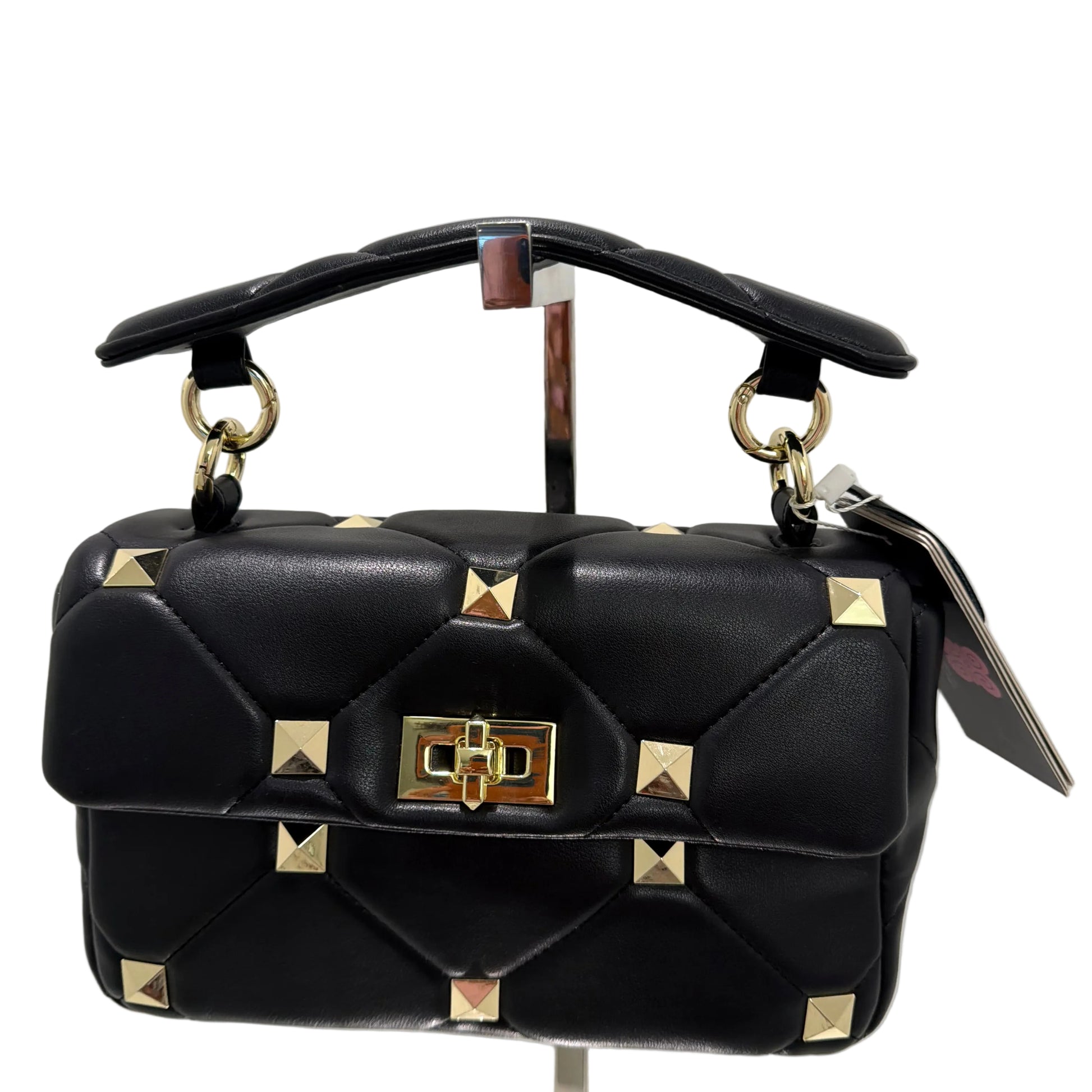Black handbag with gold studs on a light gray background