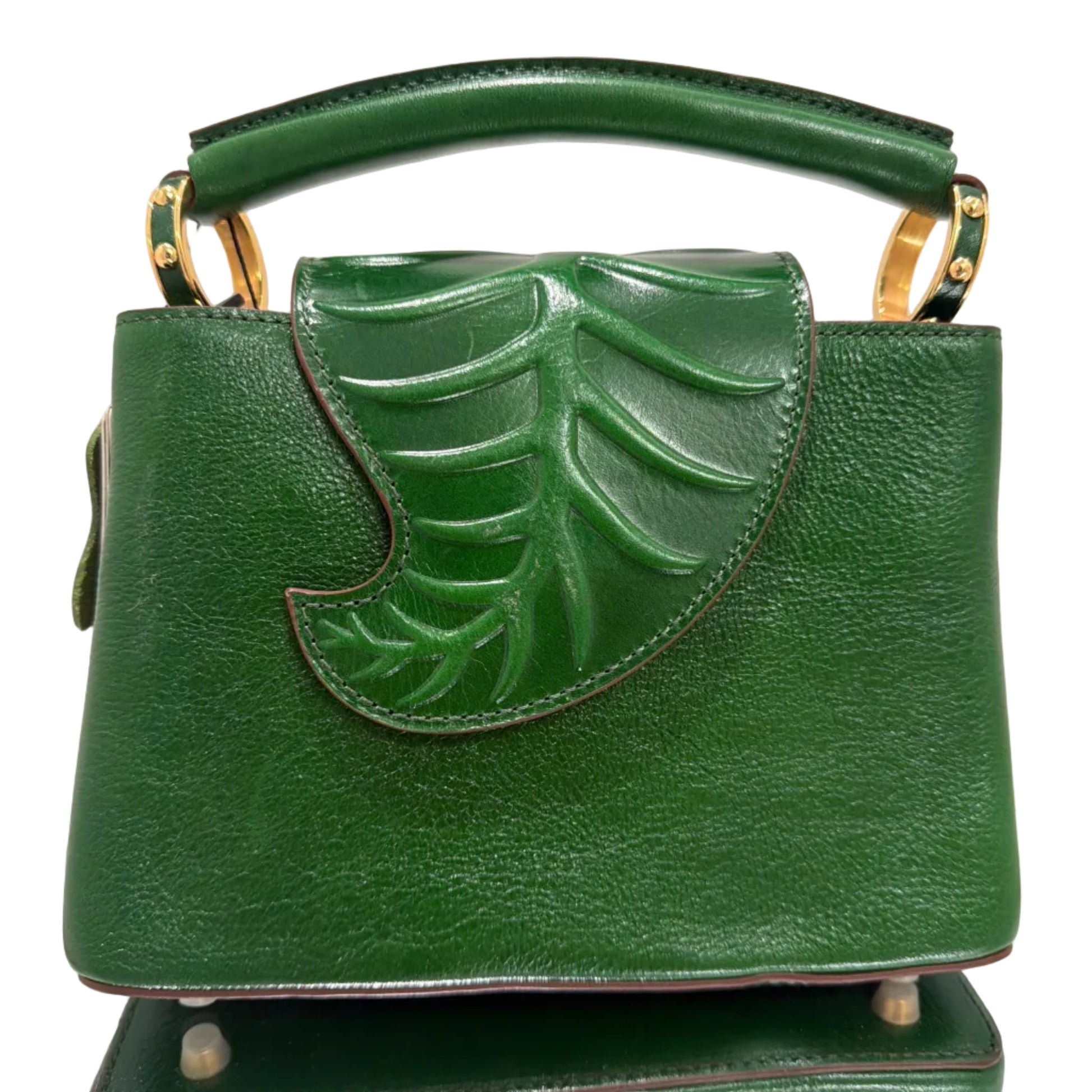 Green handbag with leaf design on a light gray background