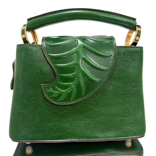 Green handbag with leaf design on a light gray background