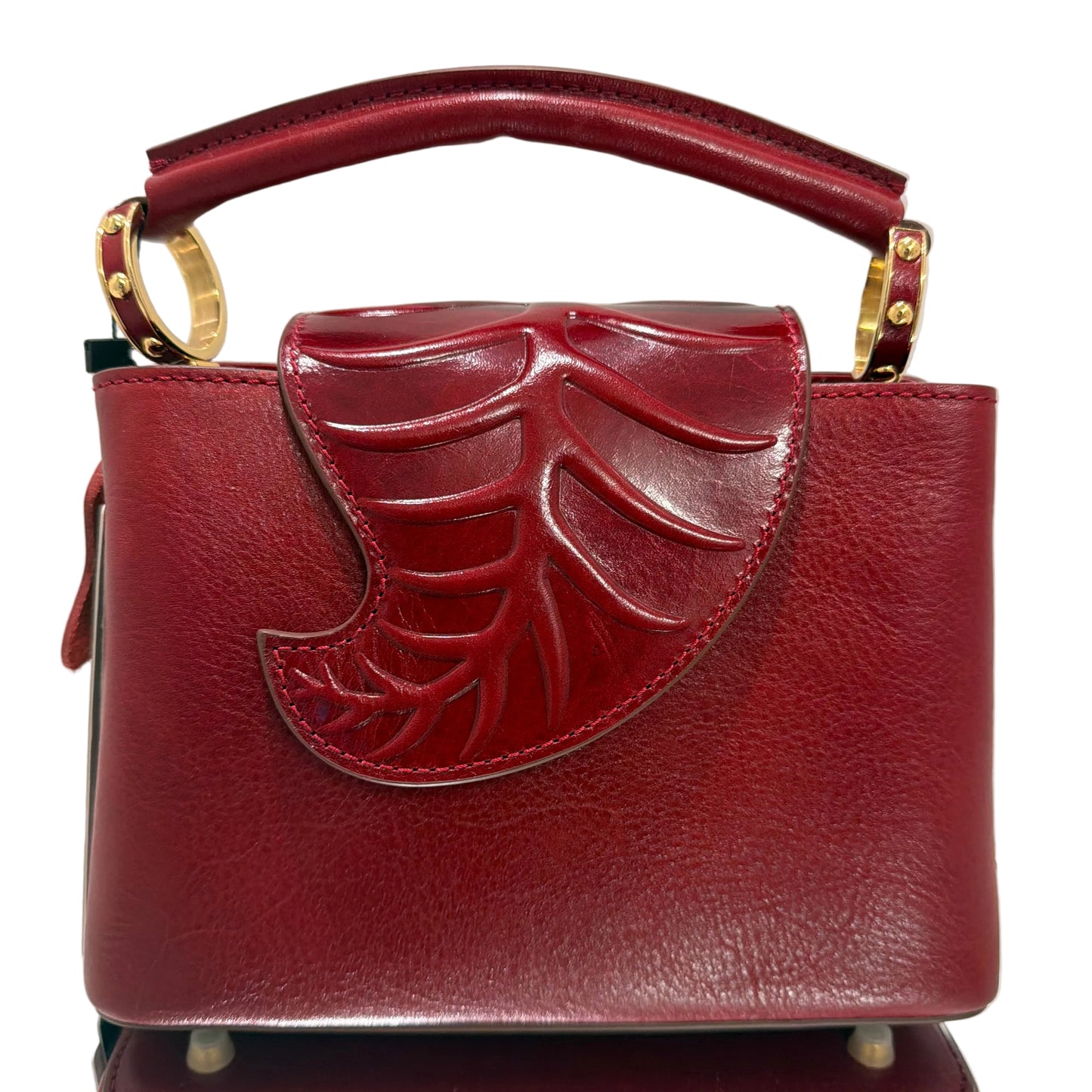 Red handbag with gold accents on a light gray background