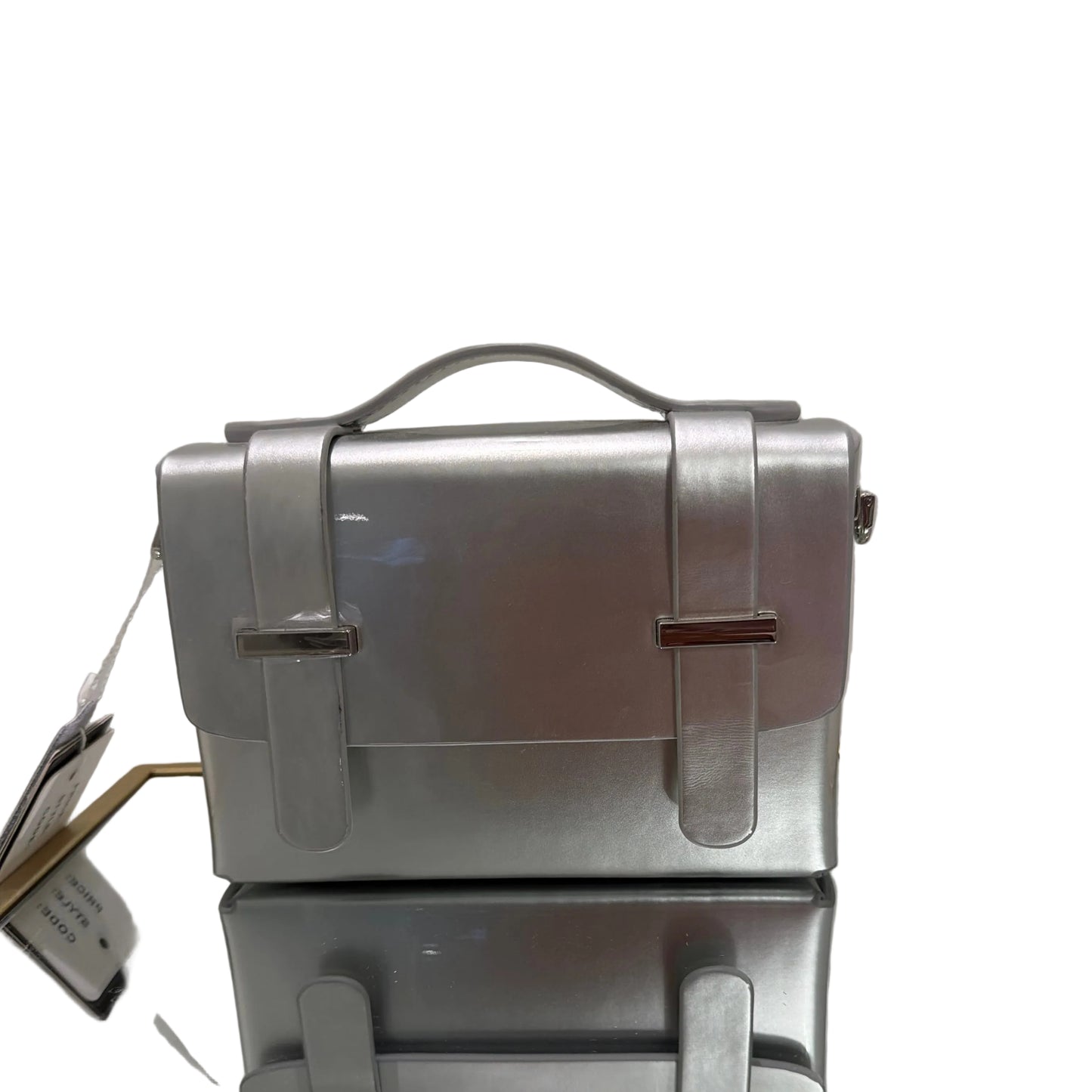 Metallic briefcase on a reflective surface with a blurred background