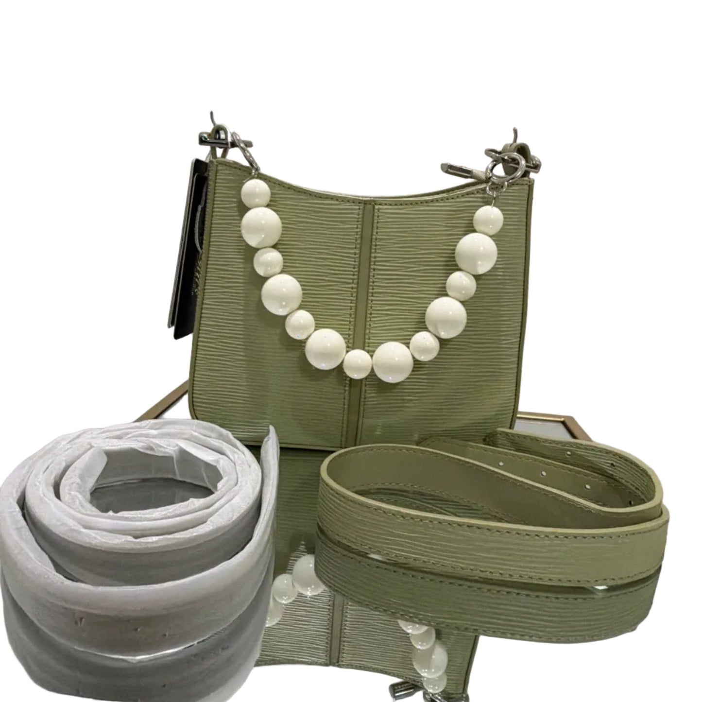 Green handbag with a decorative chain and white beads on a white background