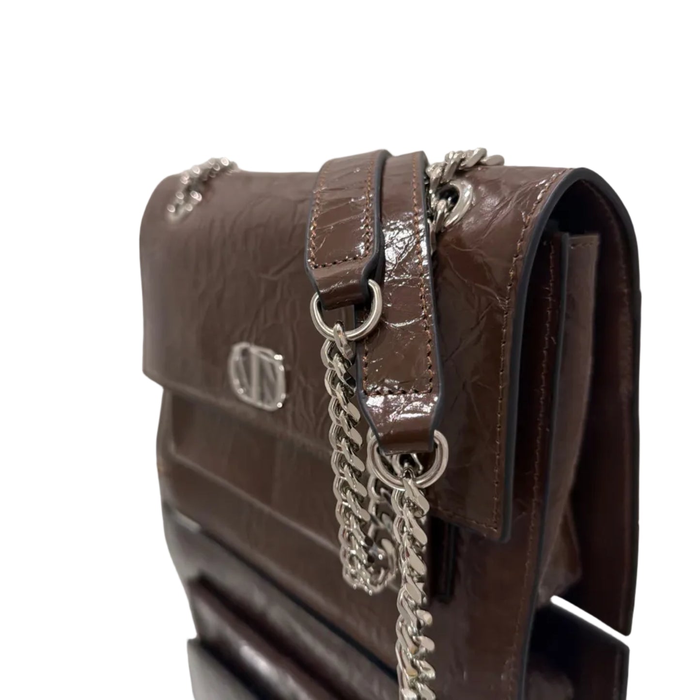 Brown handbag with chain detail on a reflective surface