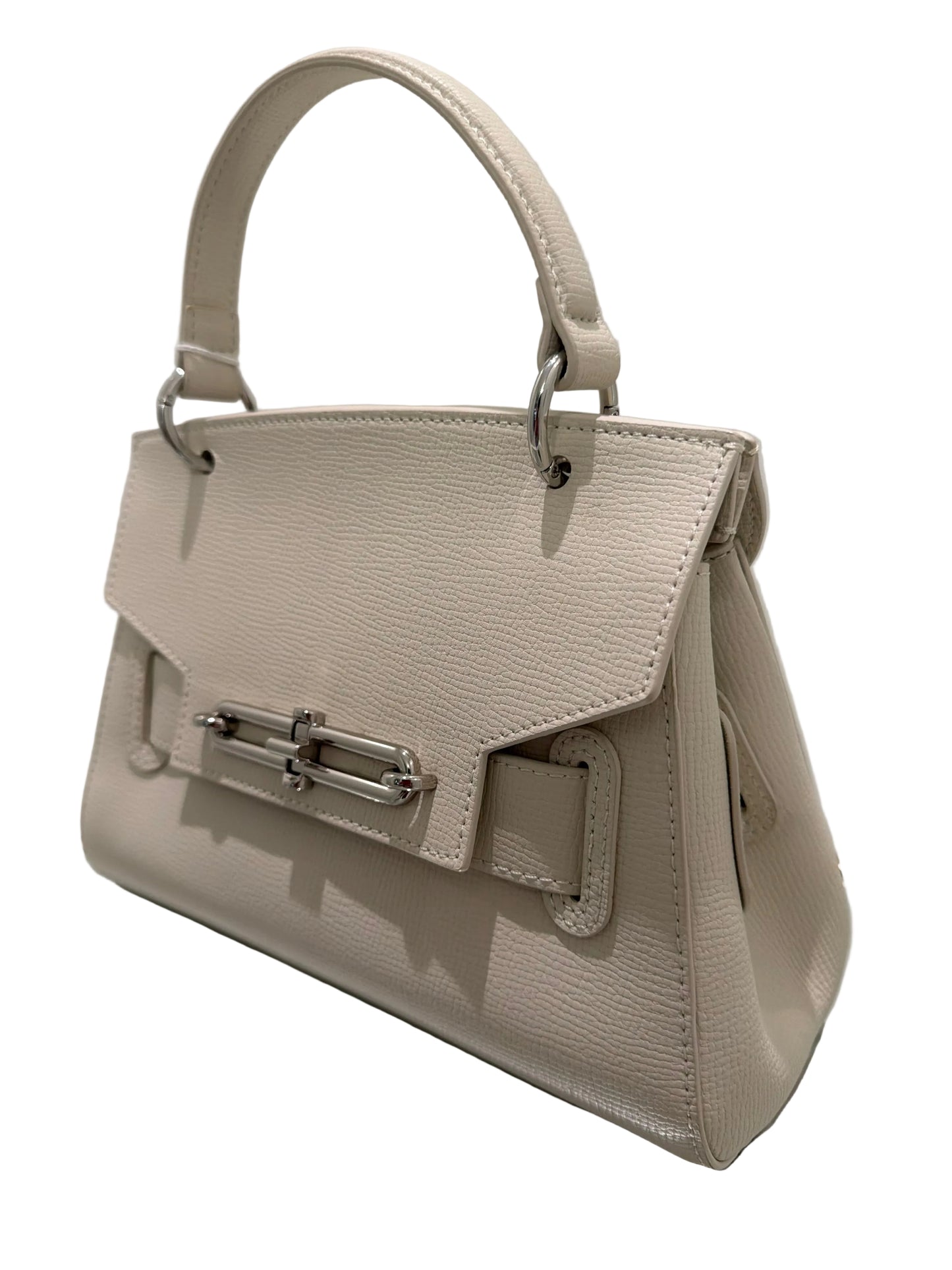 Beige handbag with a metallic clasp on a reflective surface