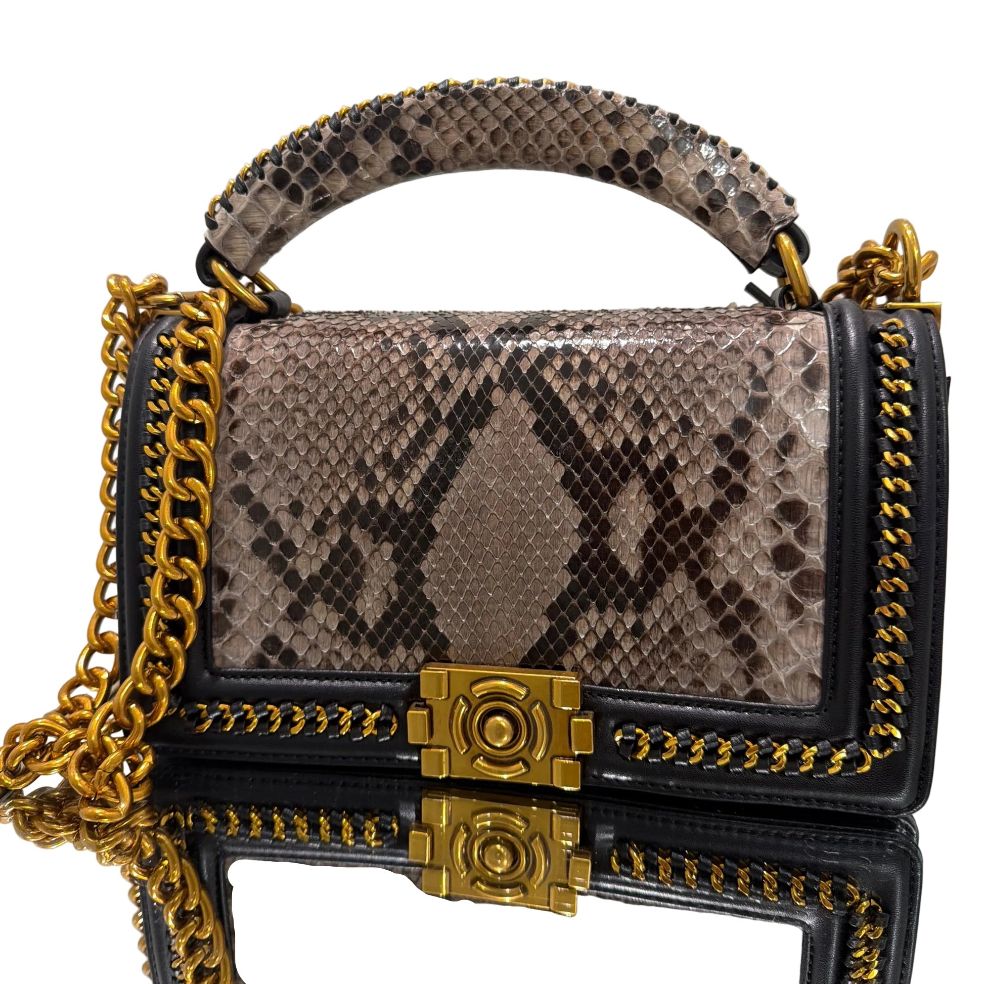 Designer handbag with snake print and gold accents on a light gray background