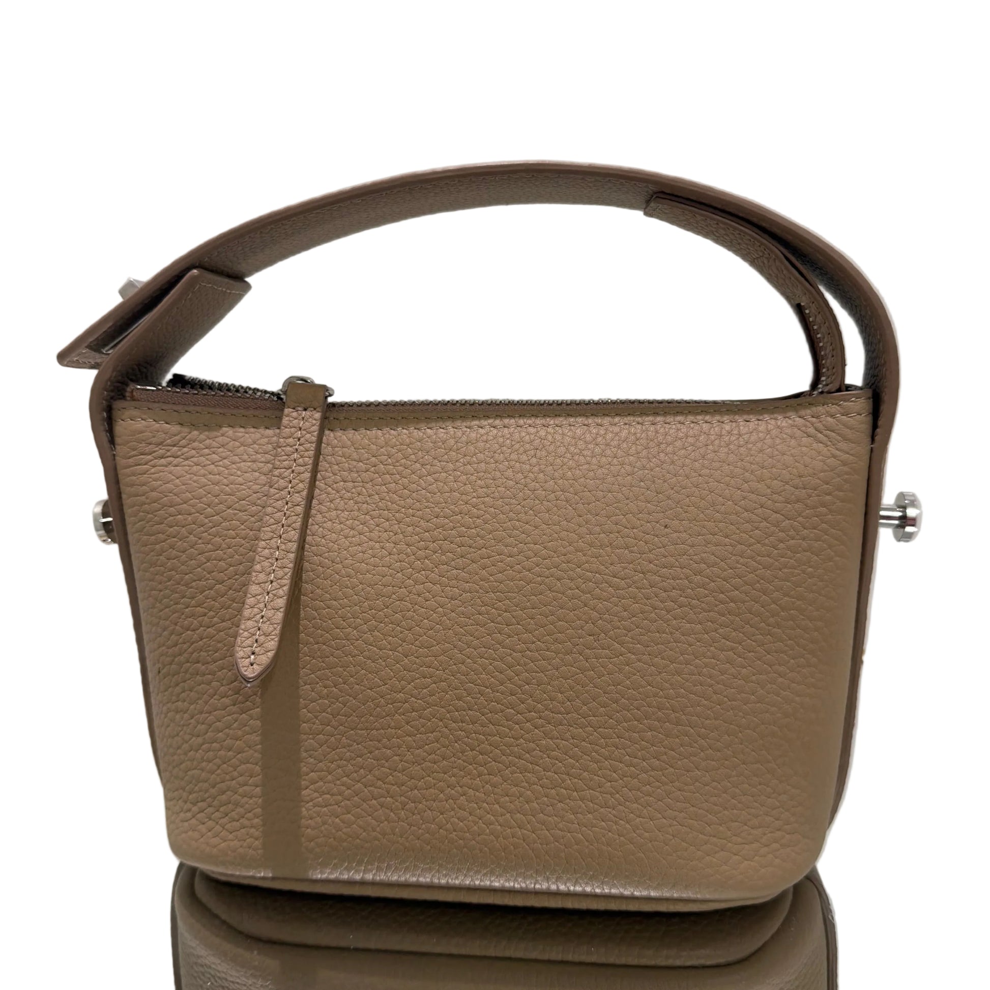 Close-up of a beige leather bag with a strap on a light gray background