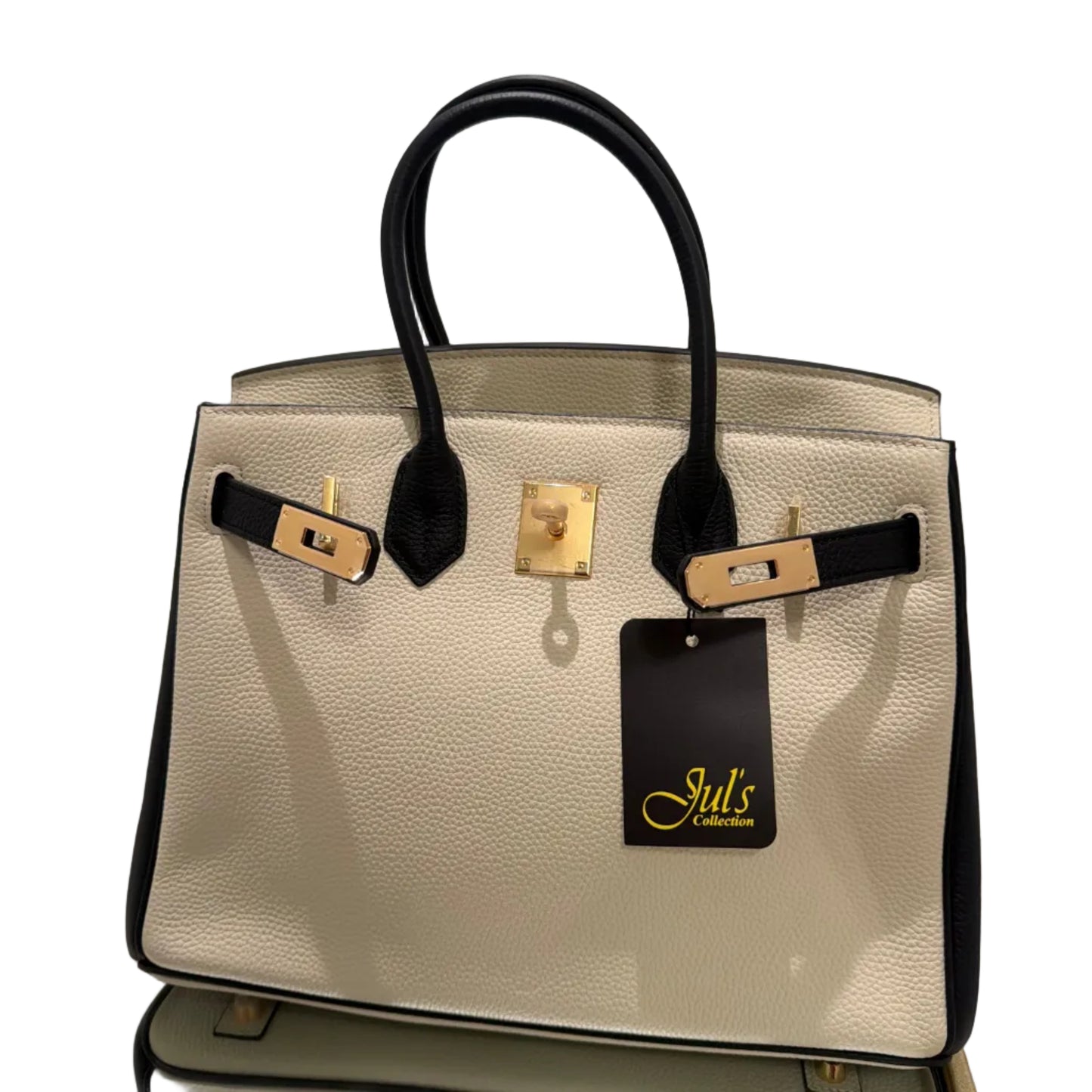 Beige handbag with black handle and gold accents on a light gray background