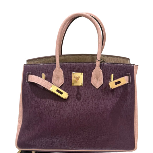Purple handbag with gold hardware on a light gray background