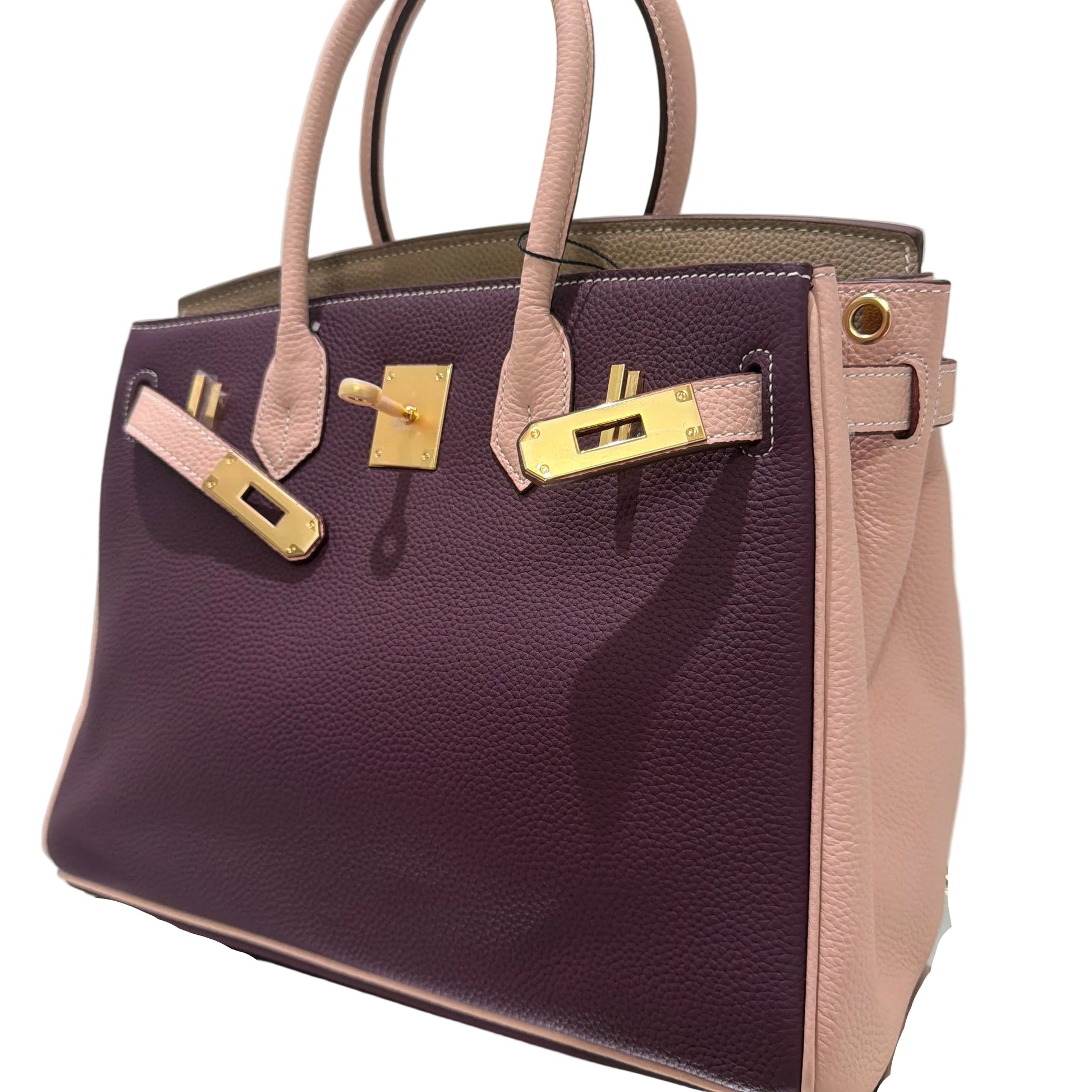 Purple handbag with gold hardware on a white background