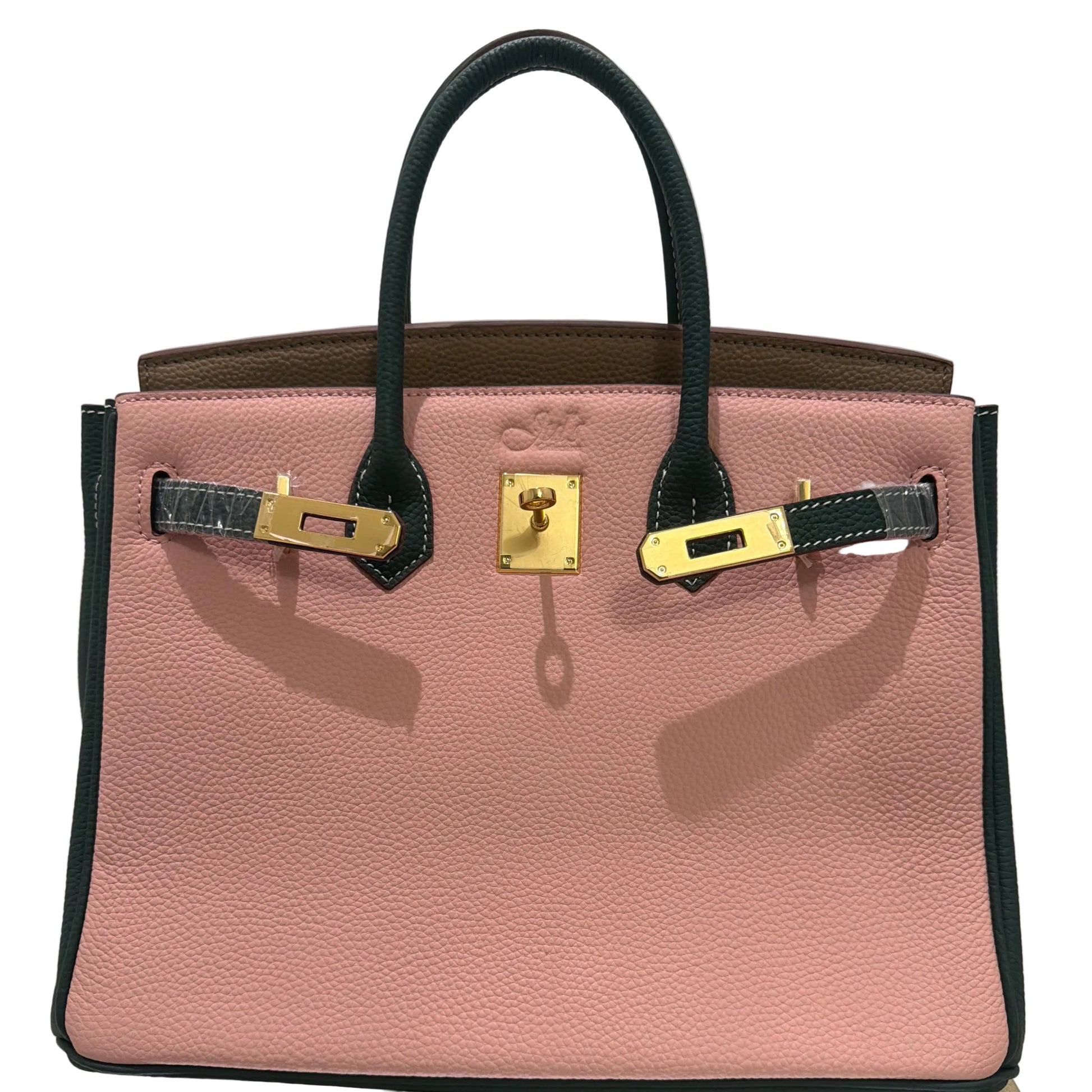 Pink handbag with gold hardware on a light gray background