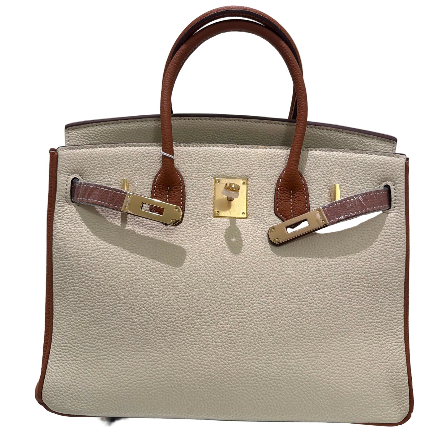 Beige handbag with brown leather accents on a light gray background