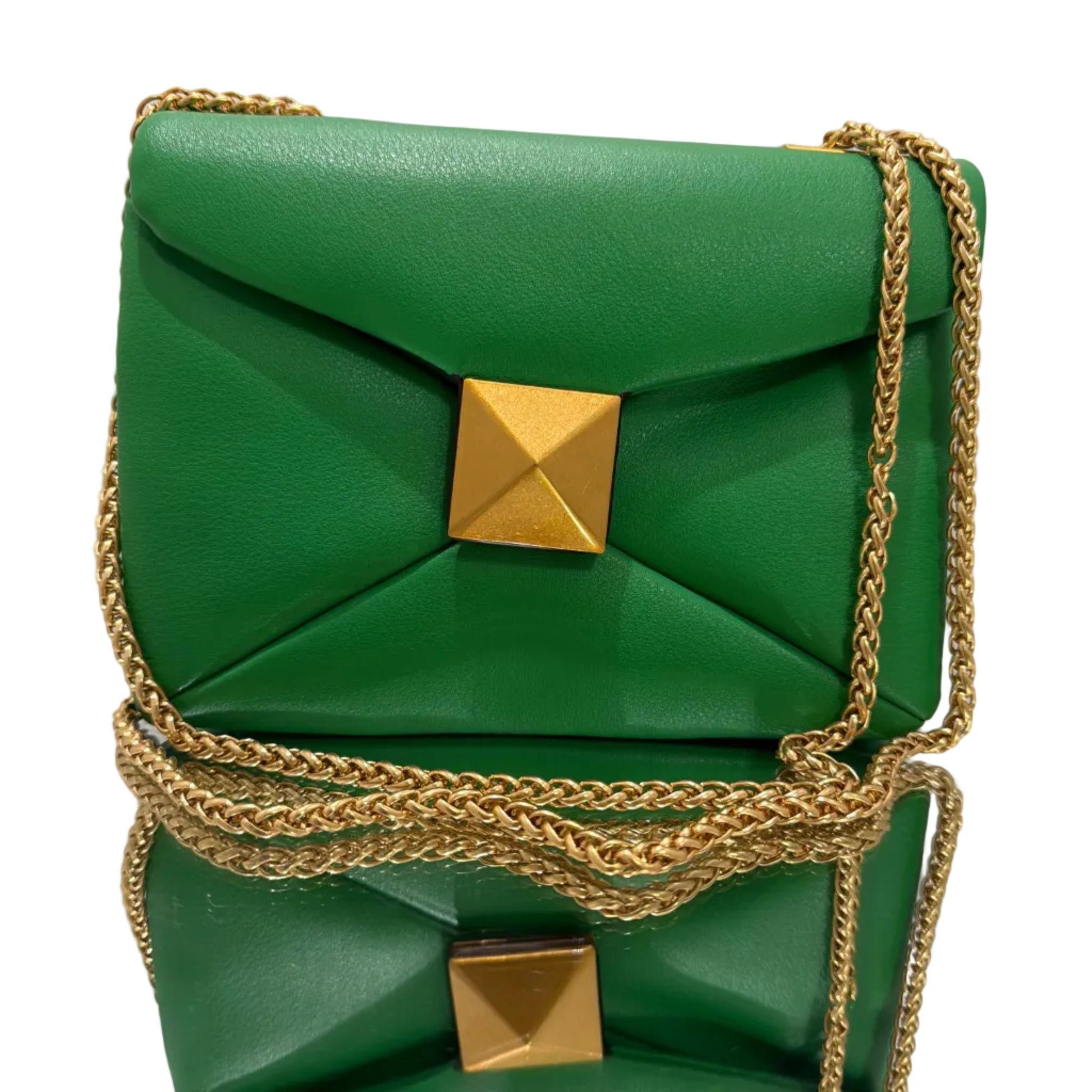 Green handbag with gold chain strap on a light gray background