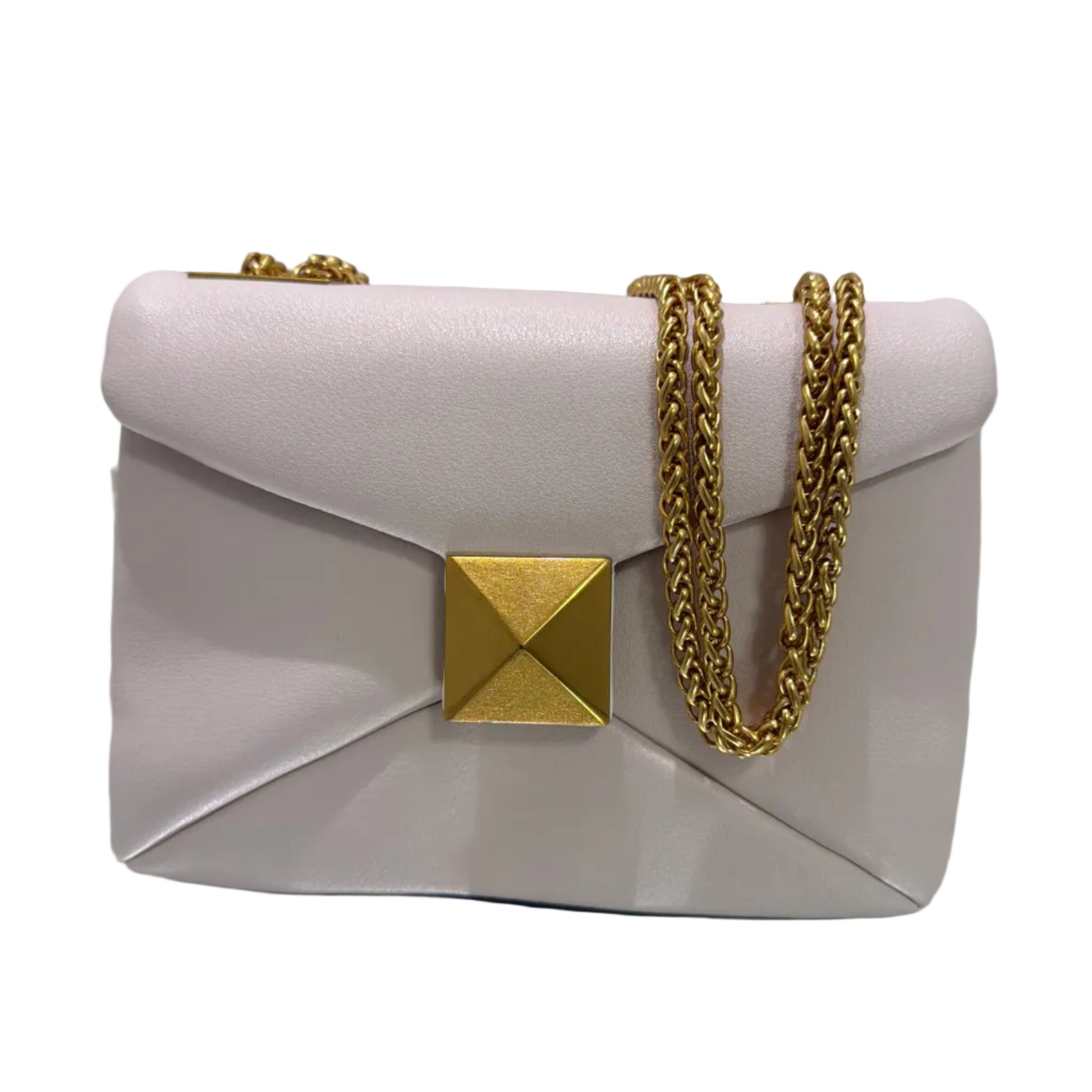 Pink handbag with gold chain and pyramid studs on a light gray background