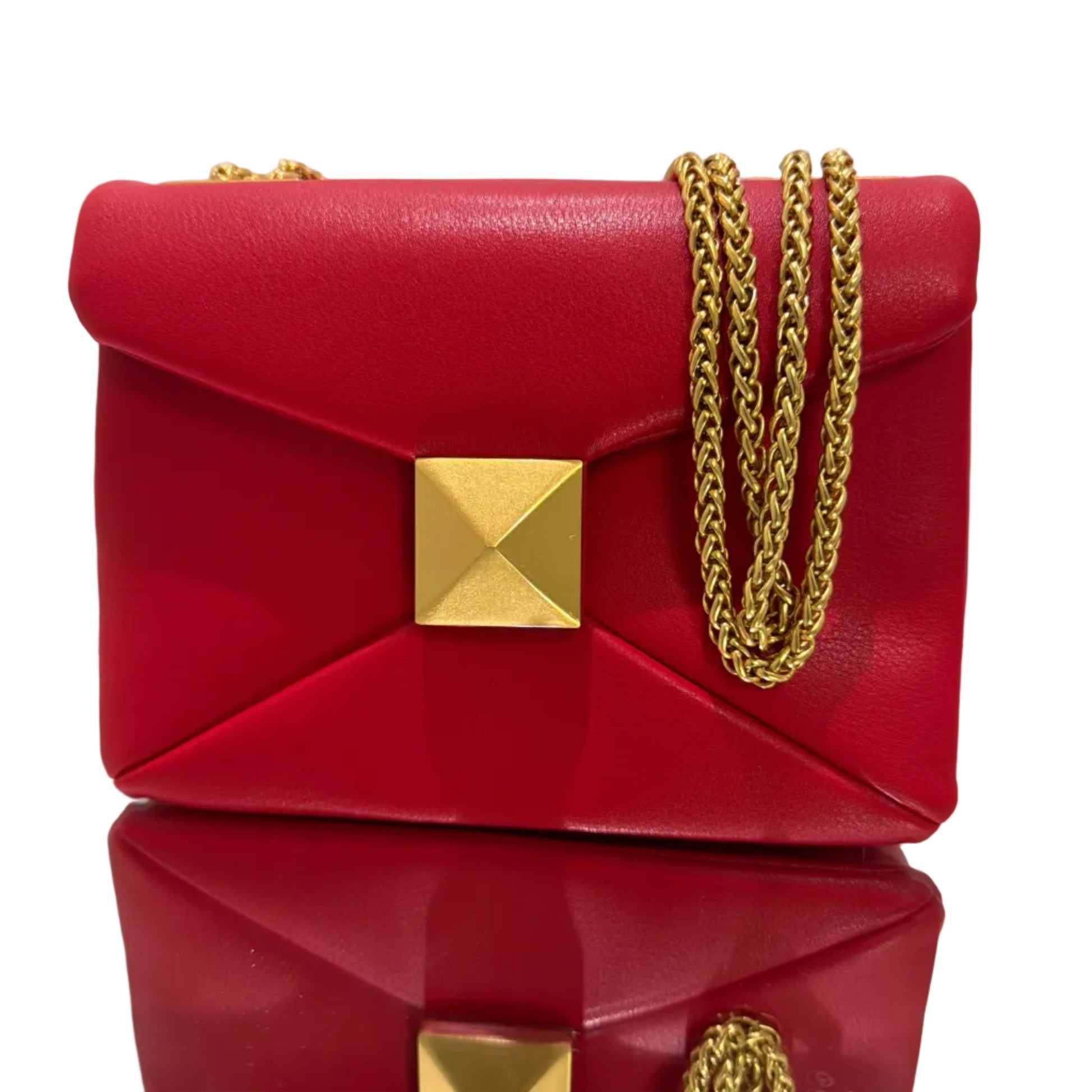 Two red handbags with gold chains and clasp on a light background