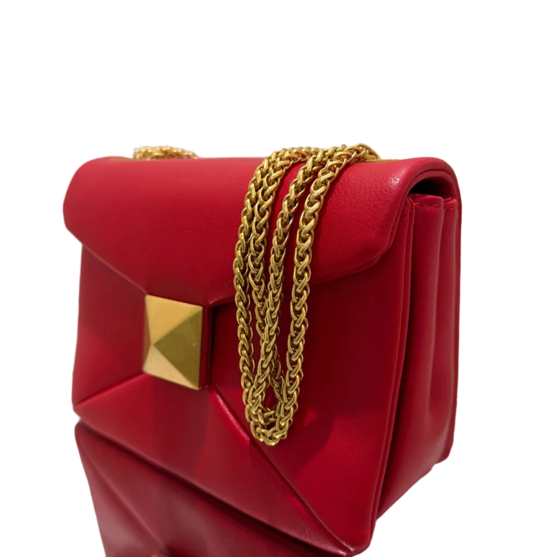 Red handbag with gold chain and studs on a light background