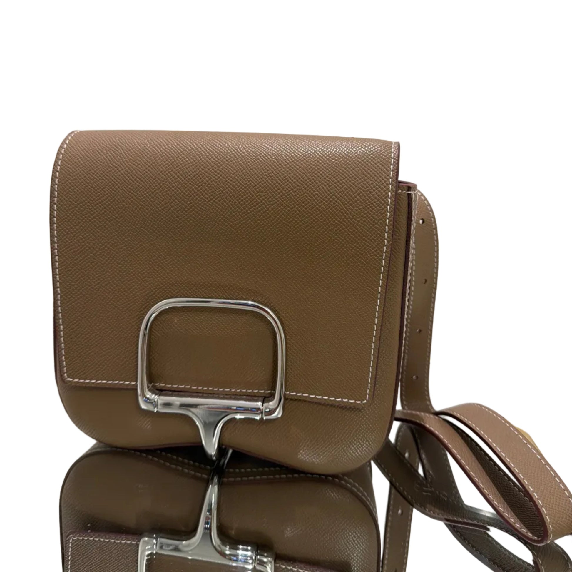 Brown handbag with metallic buckle on a light gray background