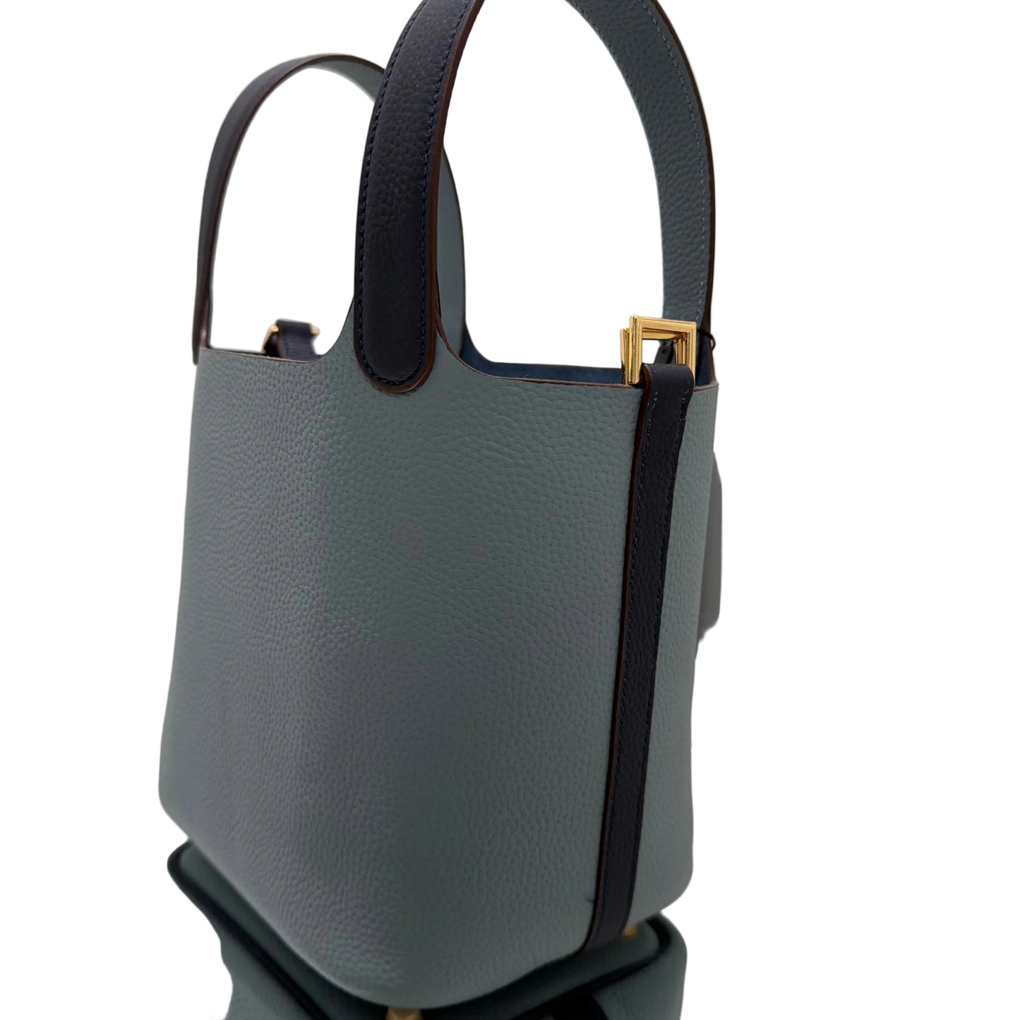 Gray handbag with black strap on a white surface