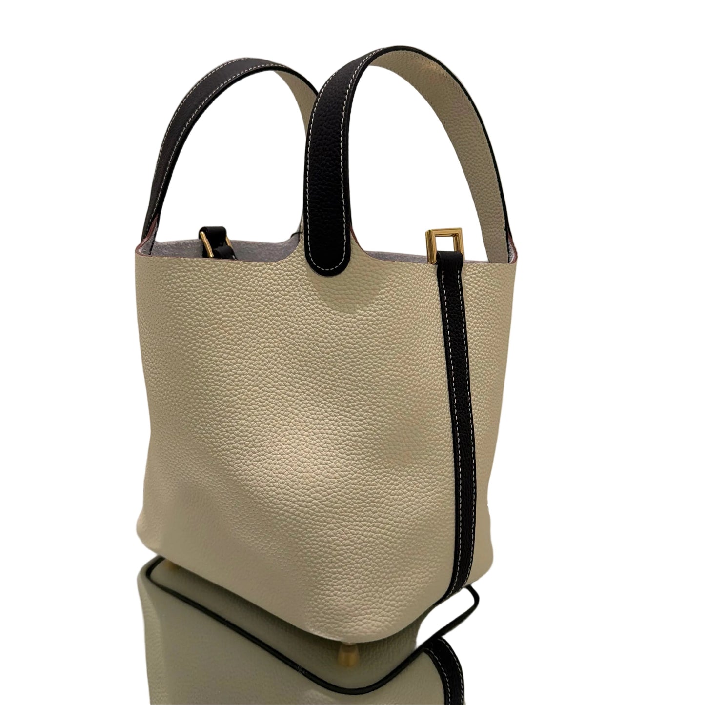 Beige handbag with black handles on a white background