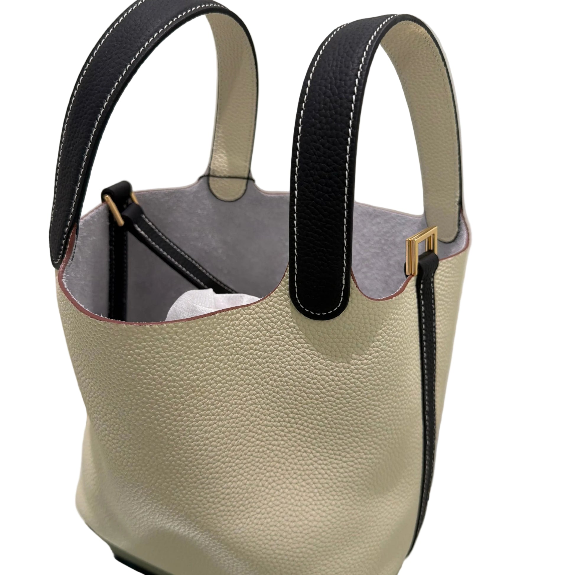 Beige leather handbag with black strap on a light background