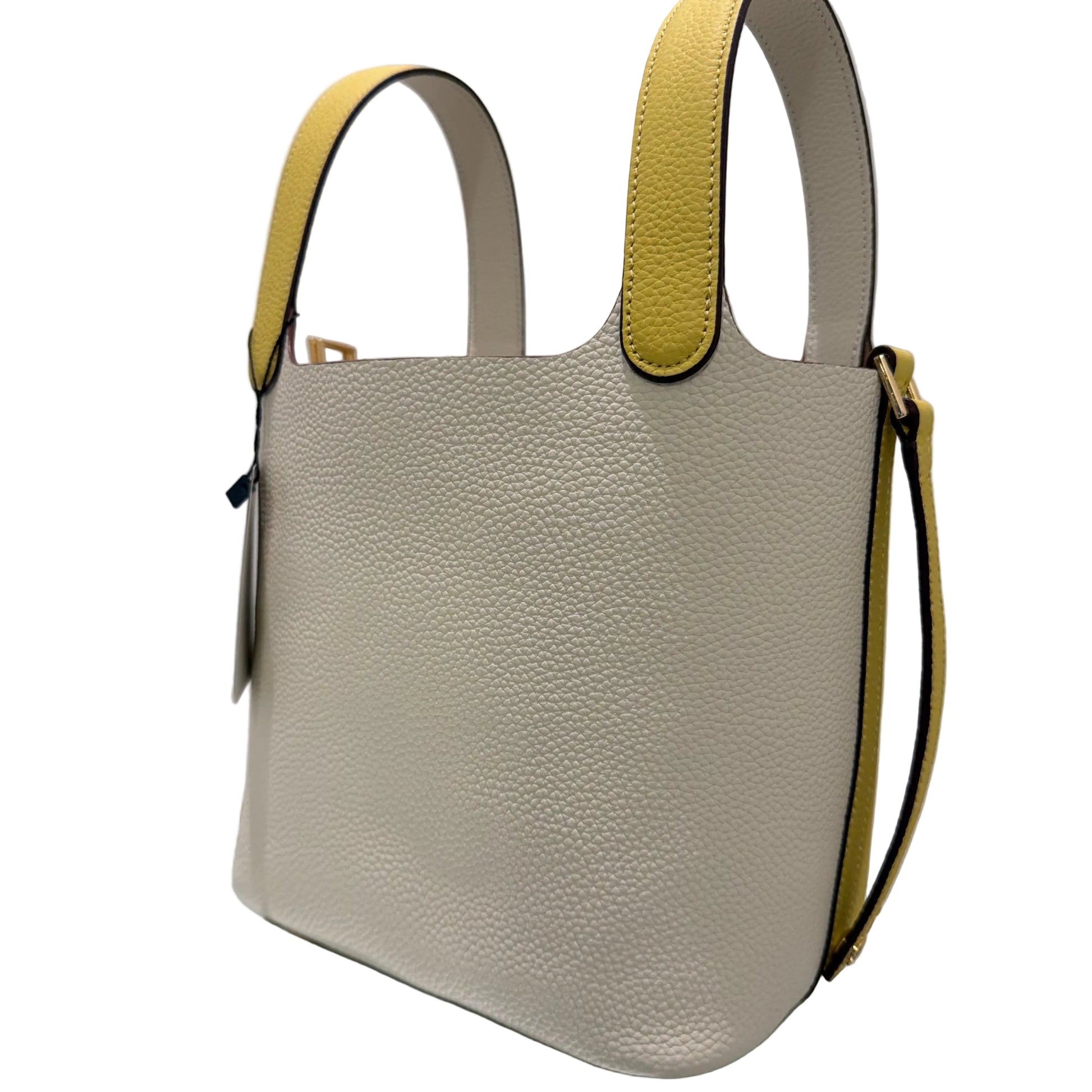 Beige handbag with yellow accents on a white surface