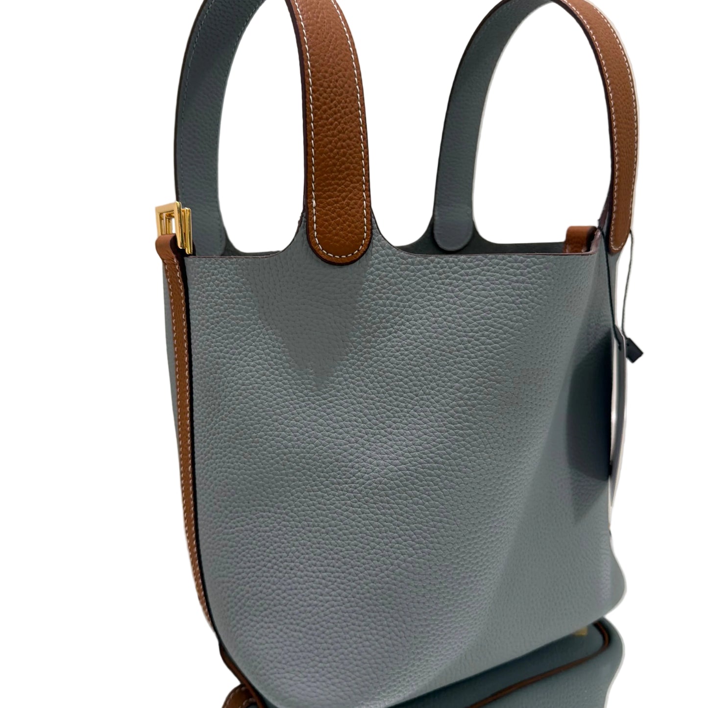 Gray handbag with brown handles on a light surface