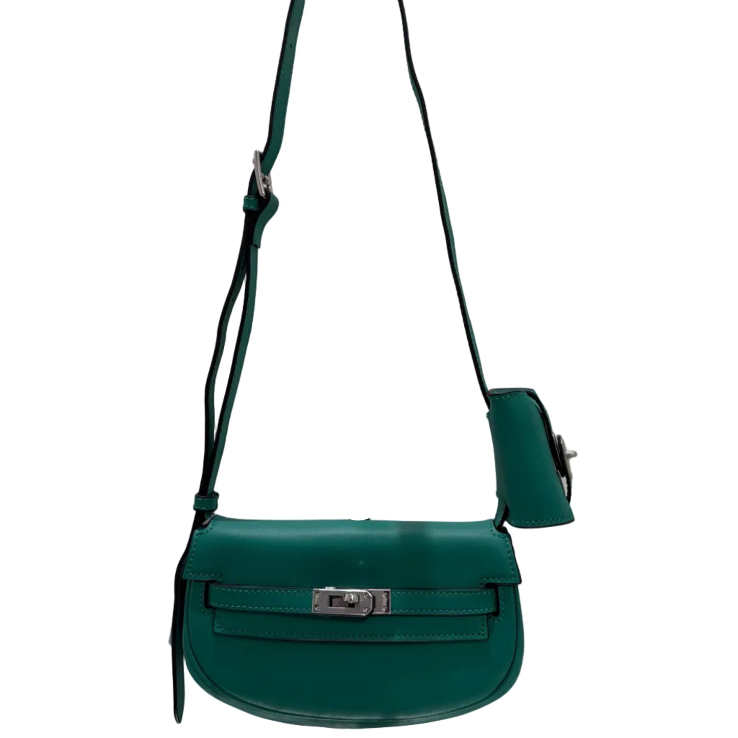 Green crossbody bag on a white surface with a mirror reflection.