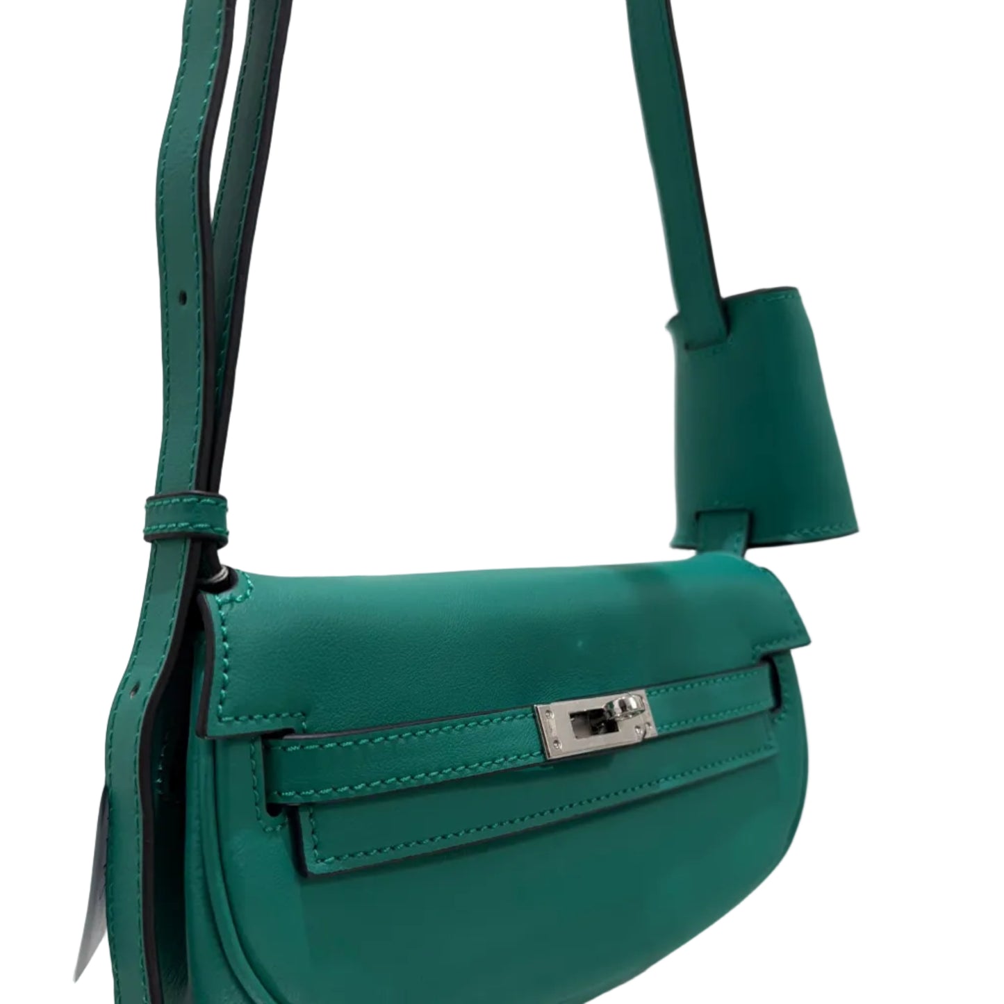 Green leather bag with a strap on a reflective surface