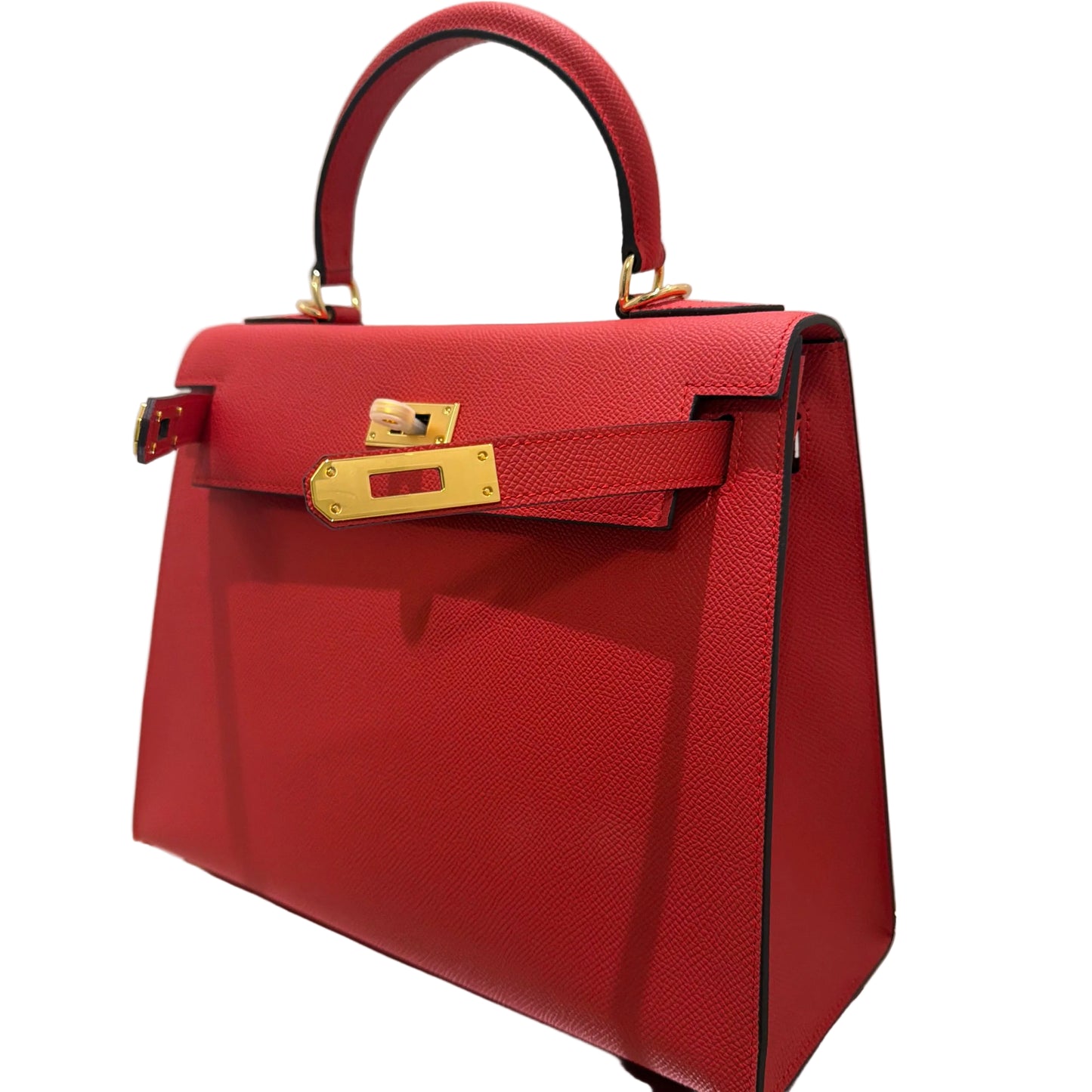 Red handbag with a gold clasp on a white surface