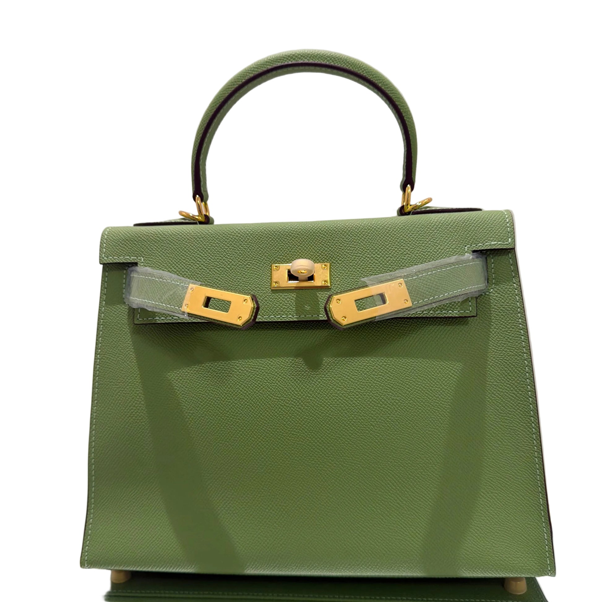 Green handbag with gold hardware on a light gray background