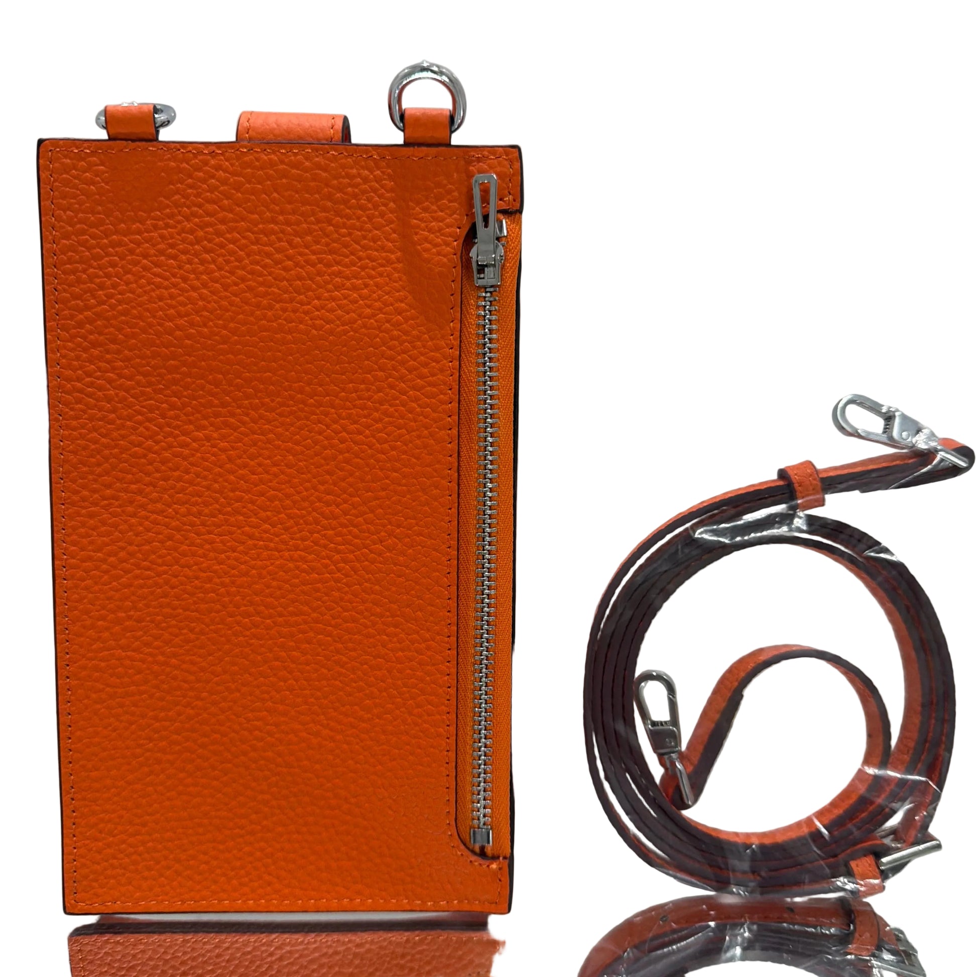 Orange leather pouch with a zipper and matching strap on a light gray background