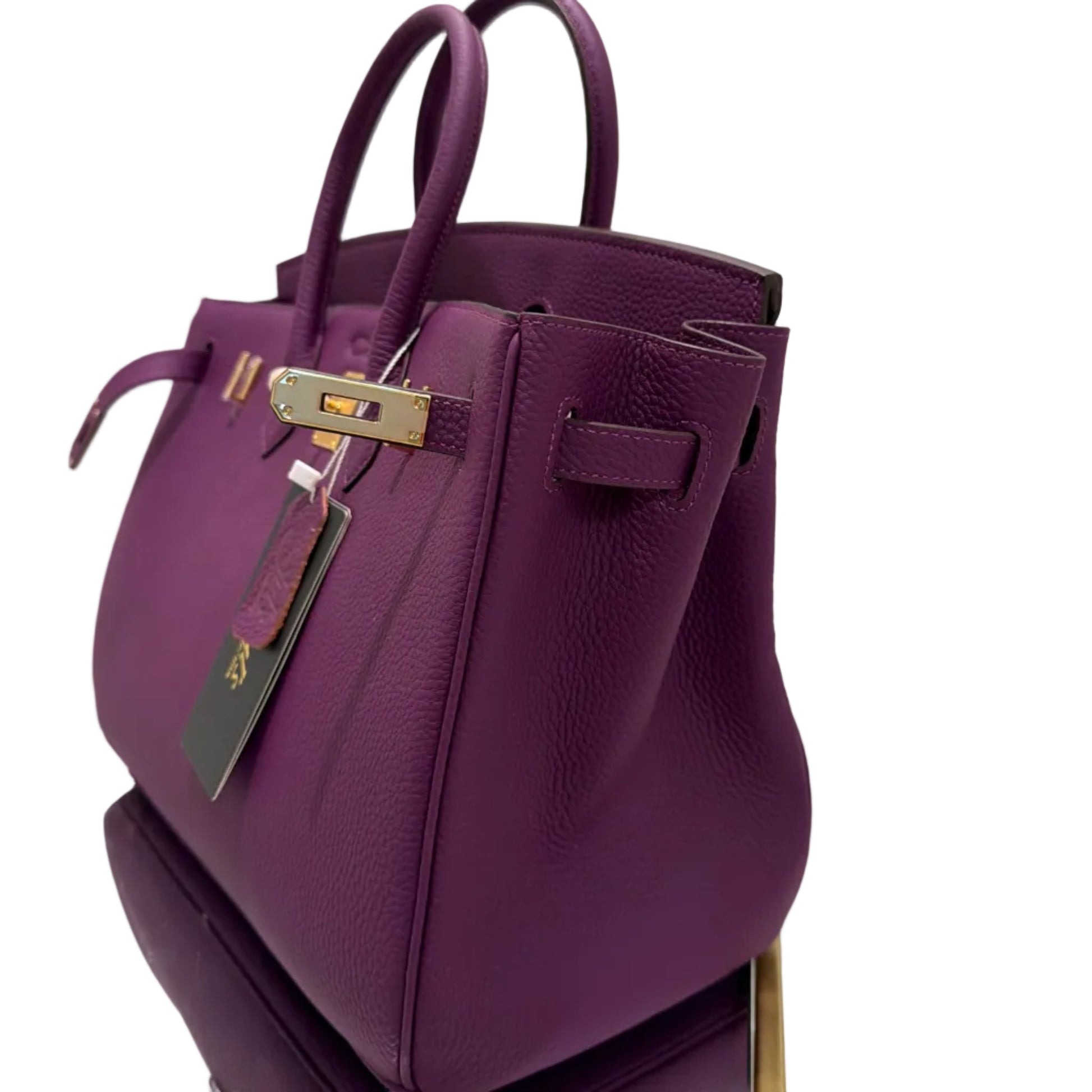 Purple handbag with gold accents on a white background