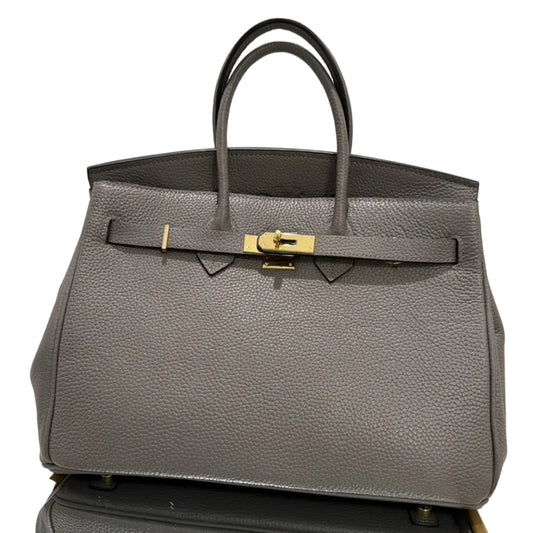 Gray textured handbag with gold clasp on a white background
