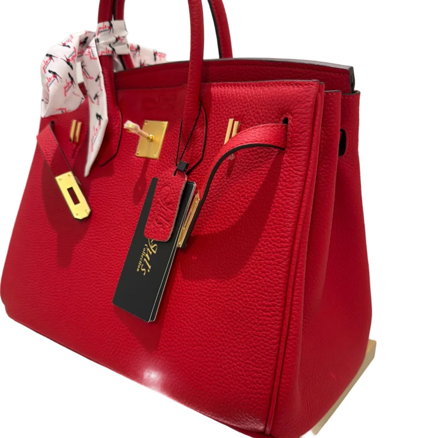 Red handbag with gold accents on a white surface