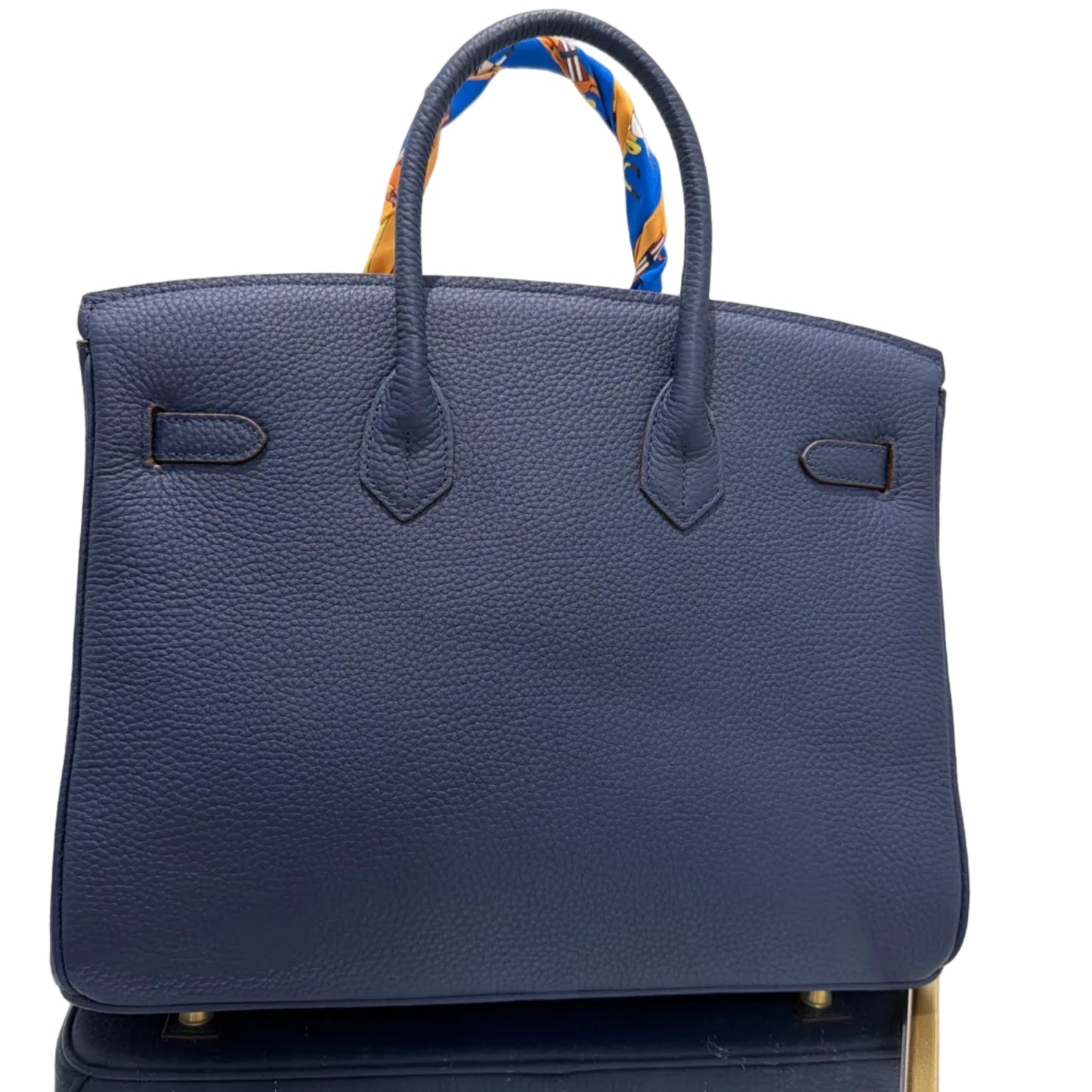 Blue handbag with a gold handle on a white background