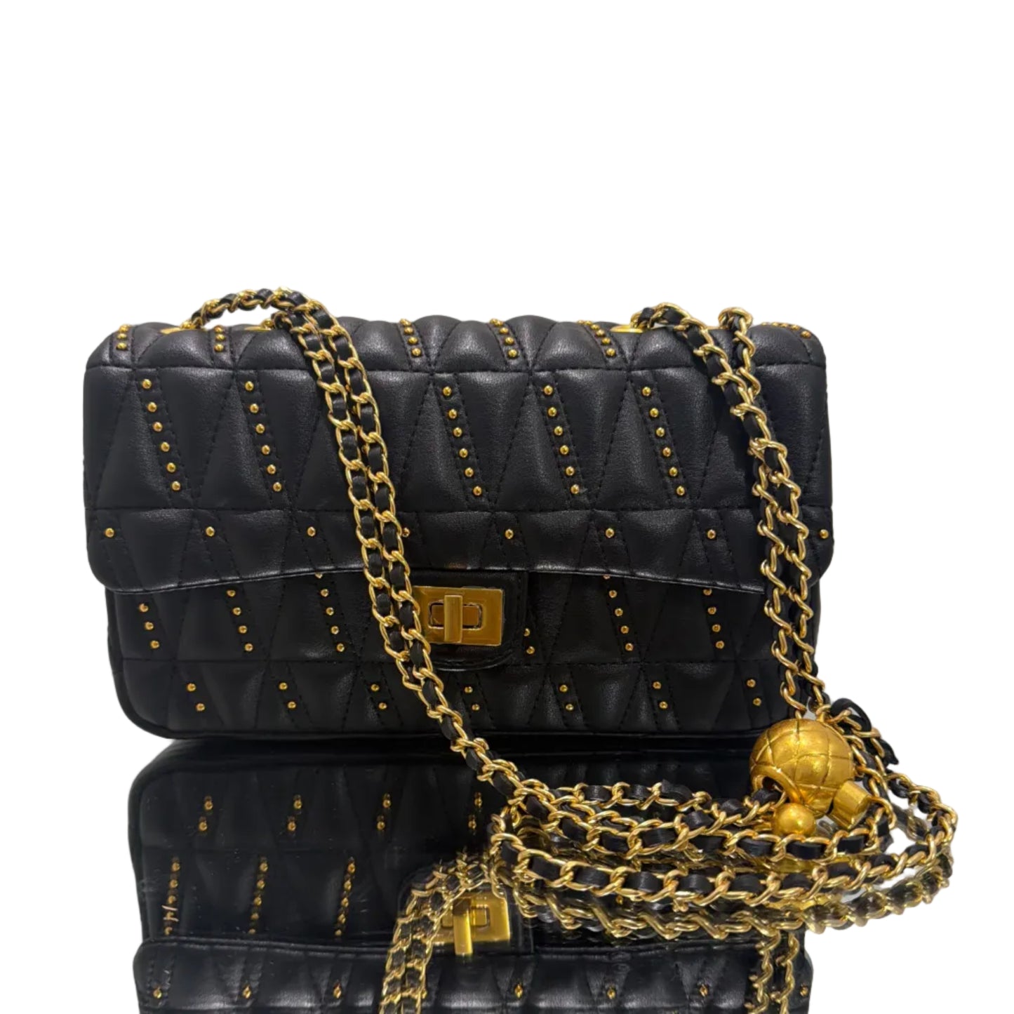 Black quilted handbag with gold chain strap on a light gray background