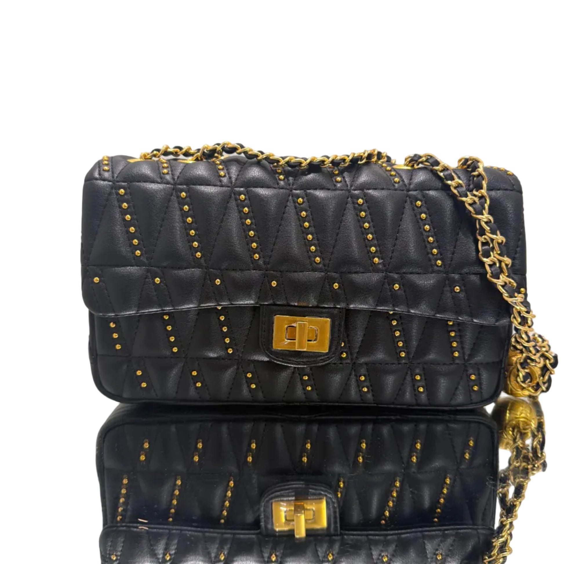 Black quilted handbag with gold chain and studs on a light gray background