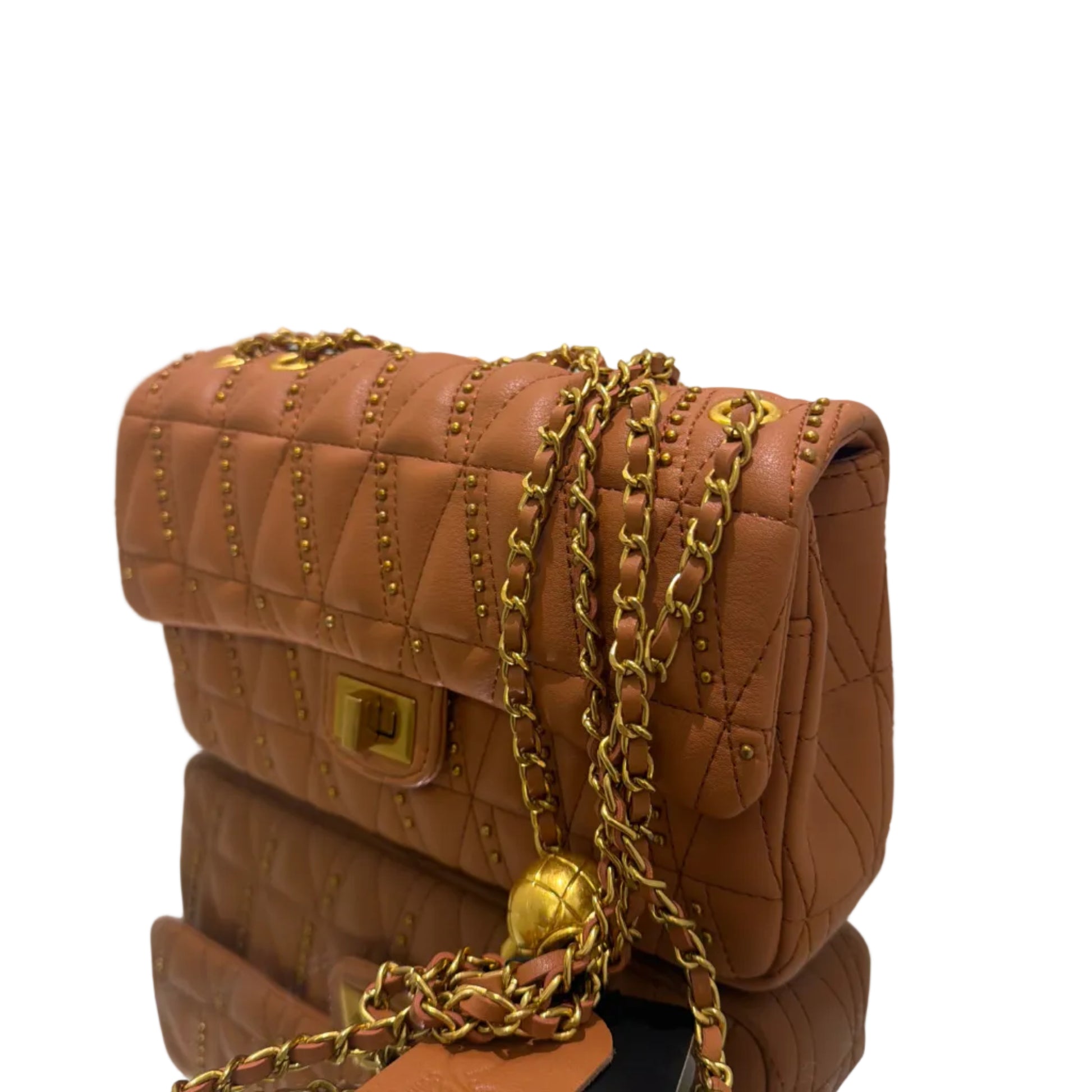 Brown quilted handbag with gold chain and hardware on a white surface.
