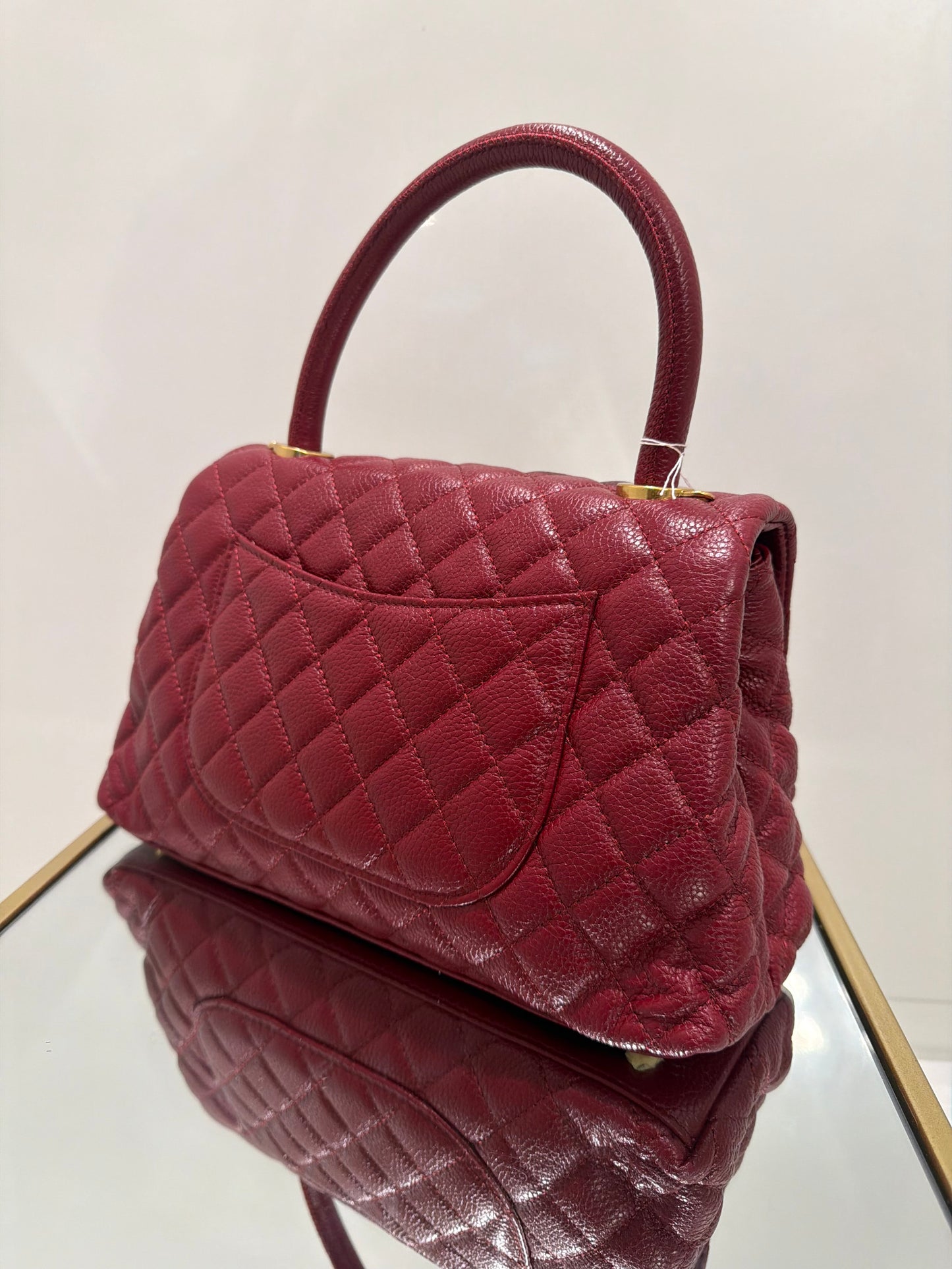 Maroon quilted handbag on a light background