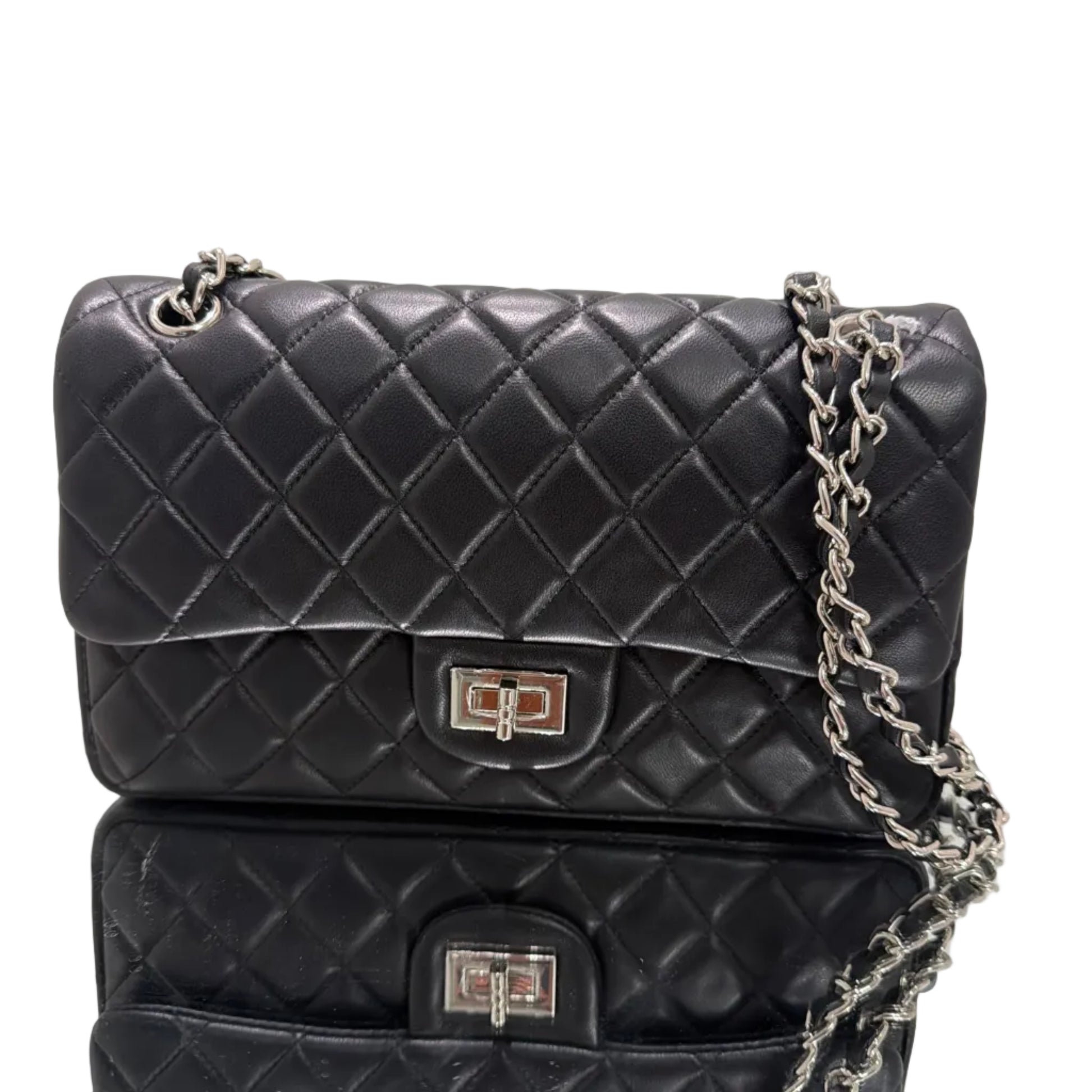 Two black quilted handbags with silver chains on a light gray background