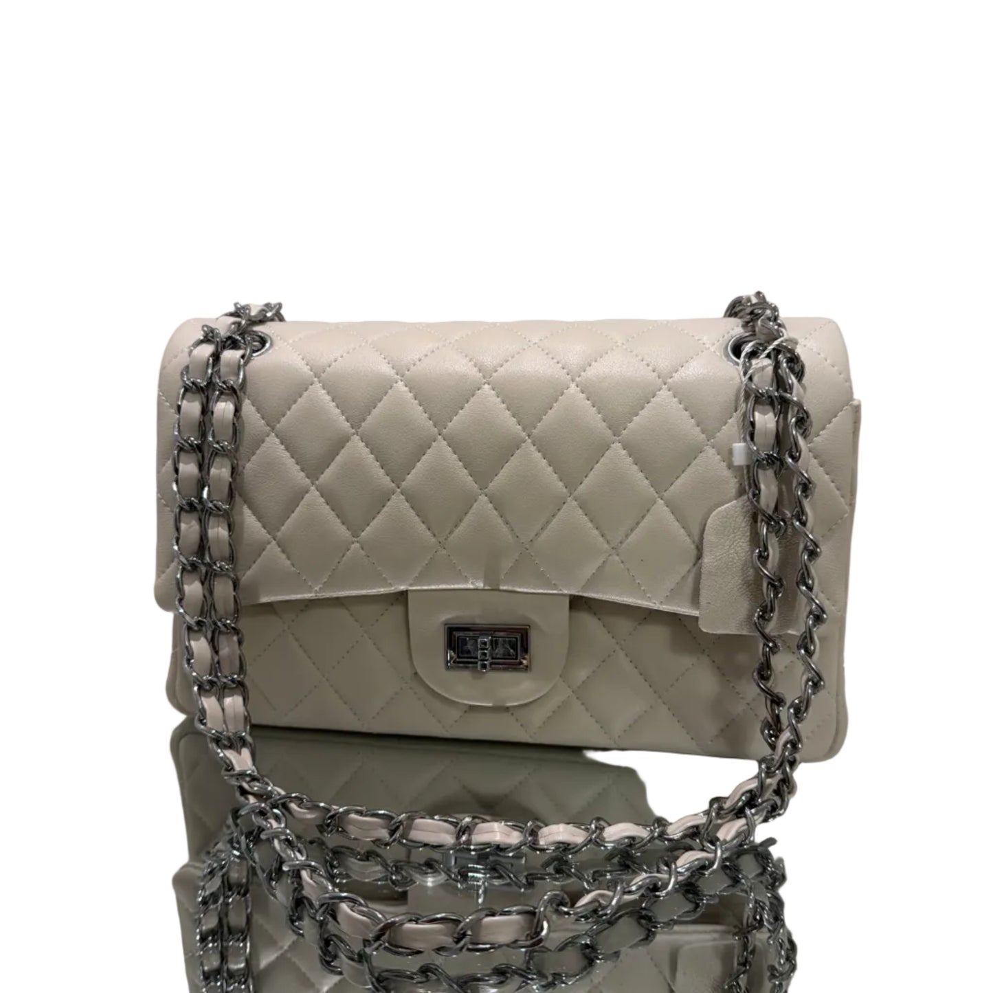 White quilted handbag with silver chain strap on a light gray background