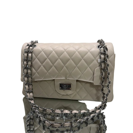 White quilted handbag with silver chain strap on a light gray background